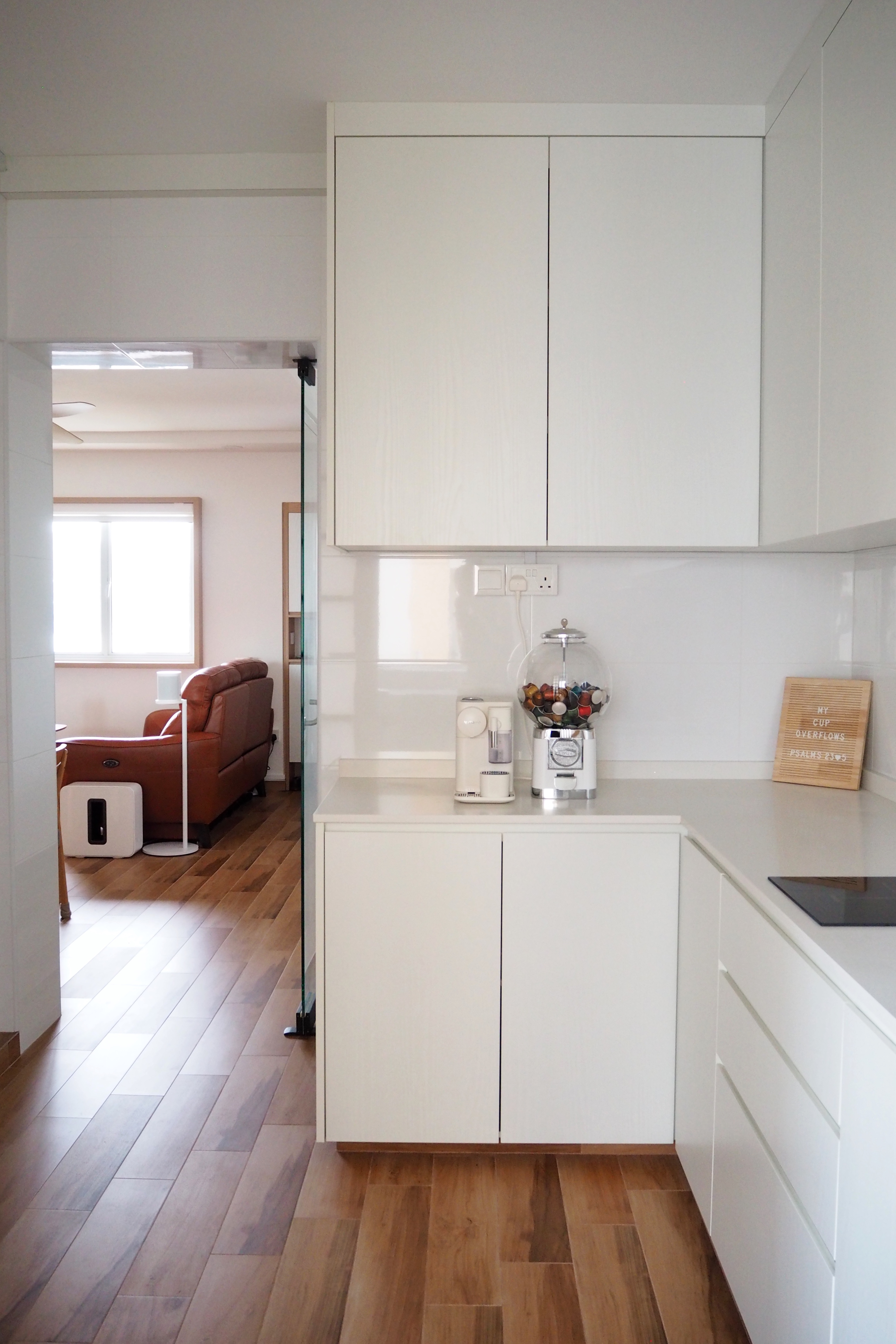 Kitchen for Coffee Lovers - White kitchen cabinets, modern design, wooden floor, cozy living room, brown leather sofa