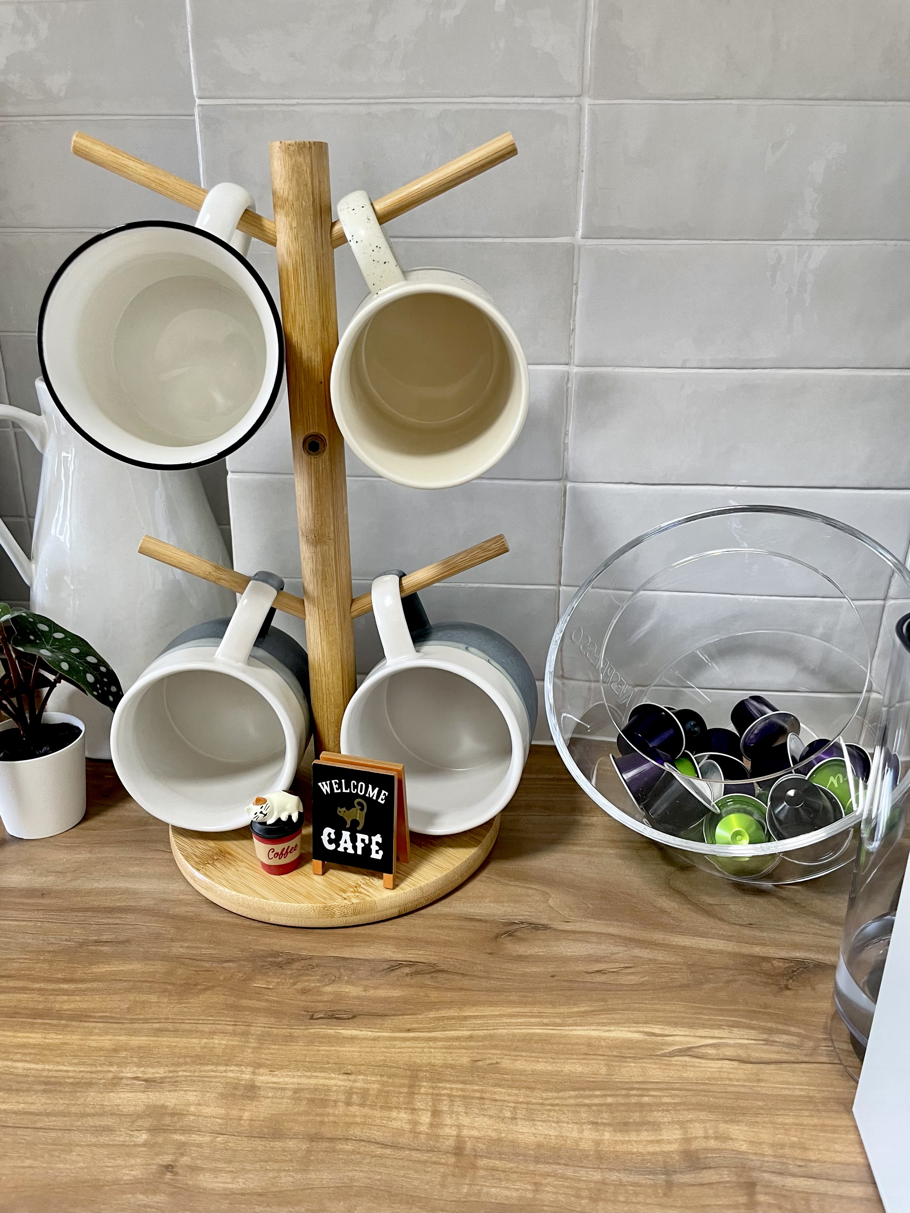 Kitchen organization with a balance for aesthetic - mug rack, ceramic mugs, wooden stand, white pitcher, empty mugs, kitchen