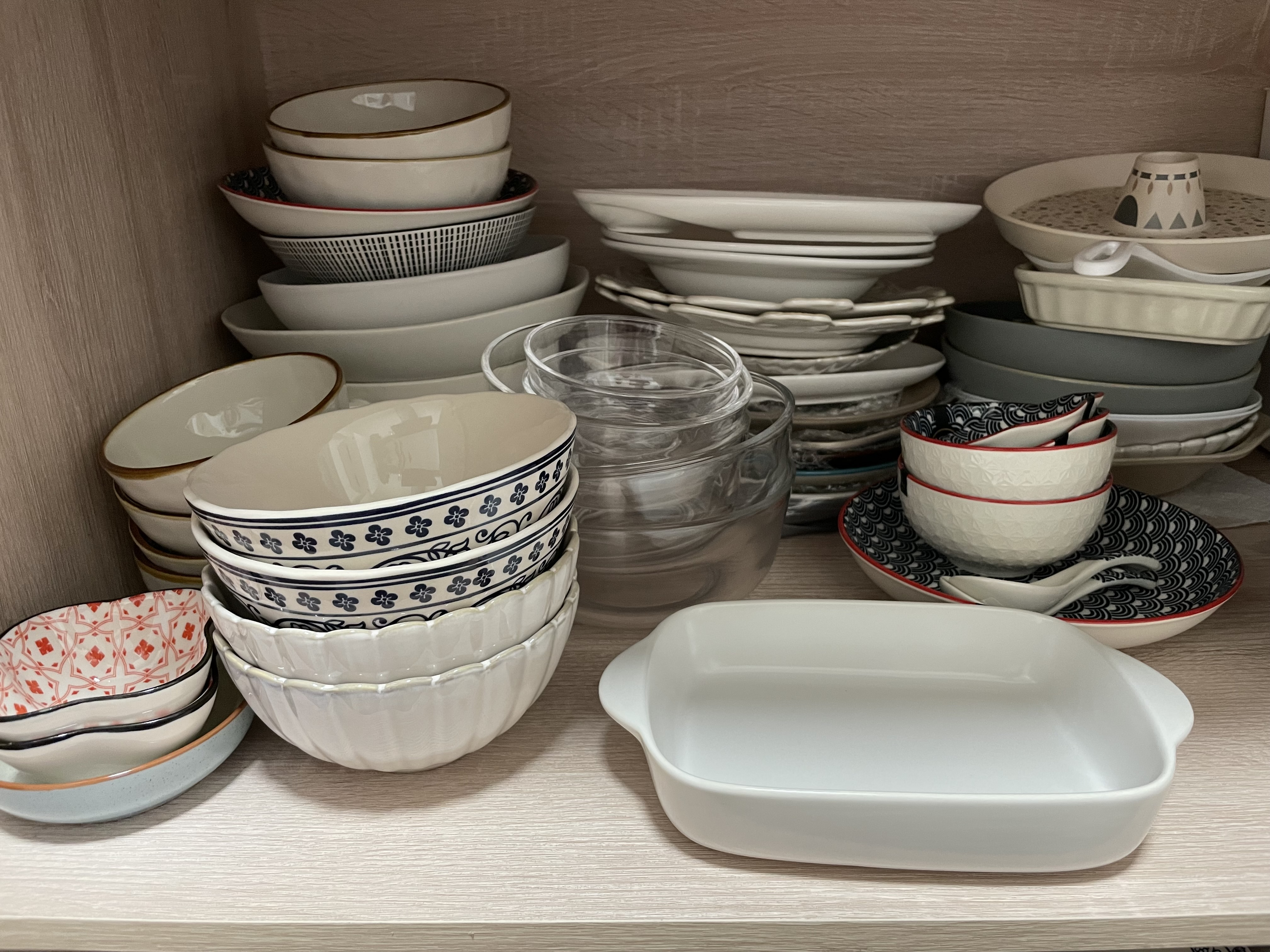 Kitchen organization with a balance for aesthetic - ceramic bowls, stacked dishes, patterned plates, glass pitcher, ceramic