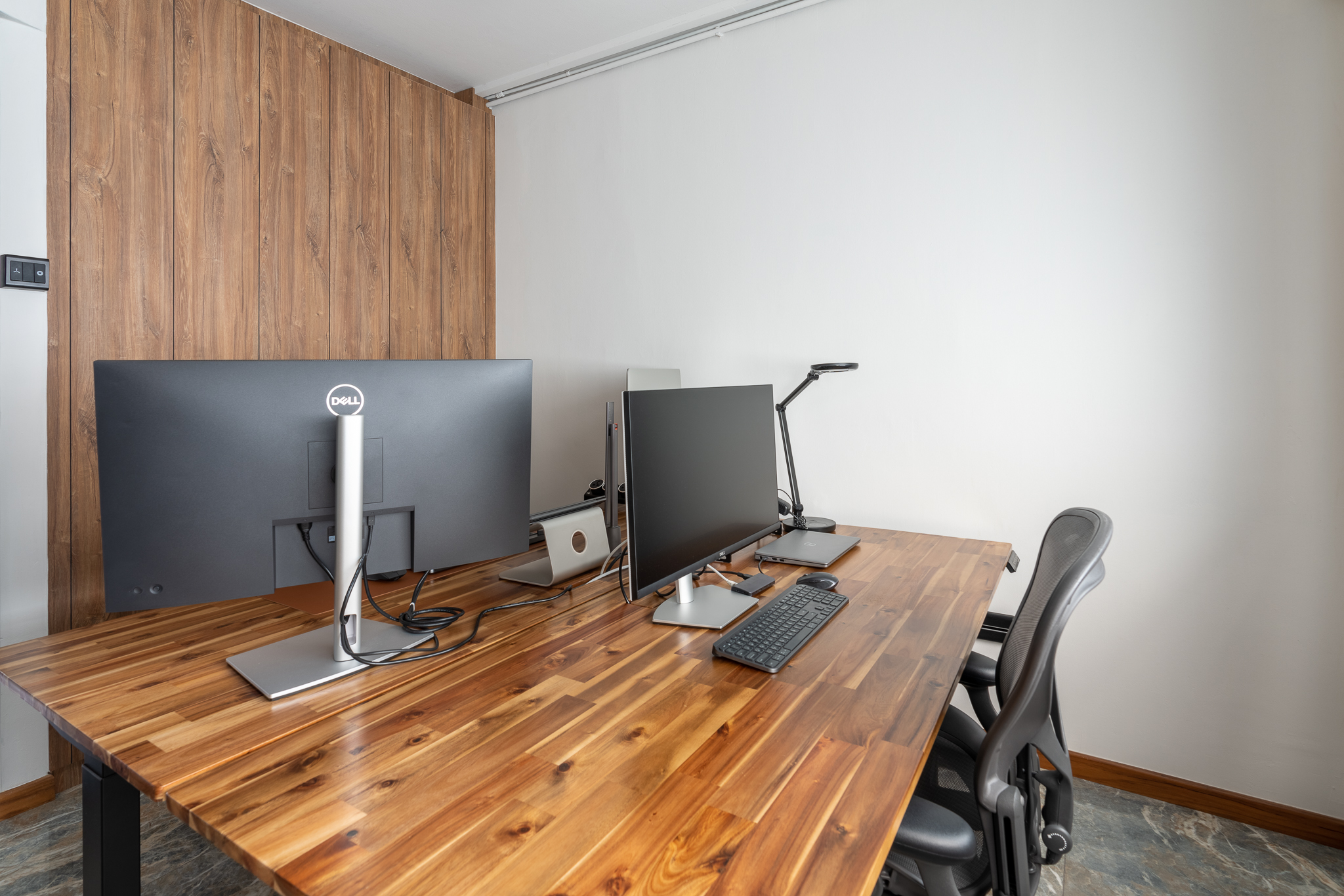 WFHappily Ever After - Wooden desk, modern office, dual monitors, ergonomic chair, black keyboard, silver desk lamp