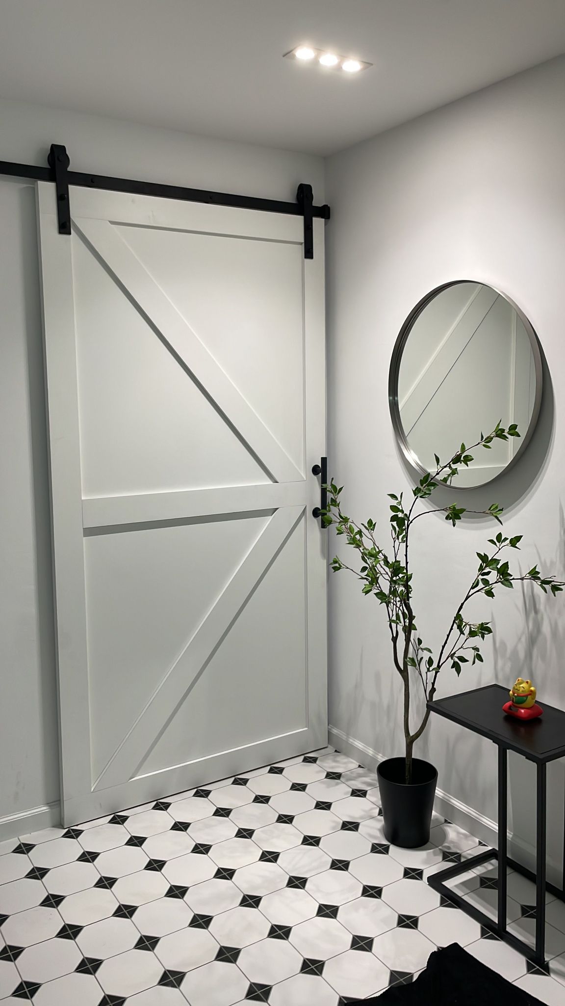 In the making with HipVan  - White double doors with black metal frame, black geometric wall mirror, black potted plant with