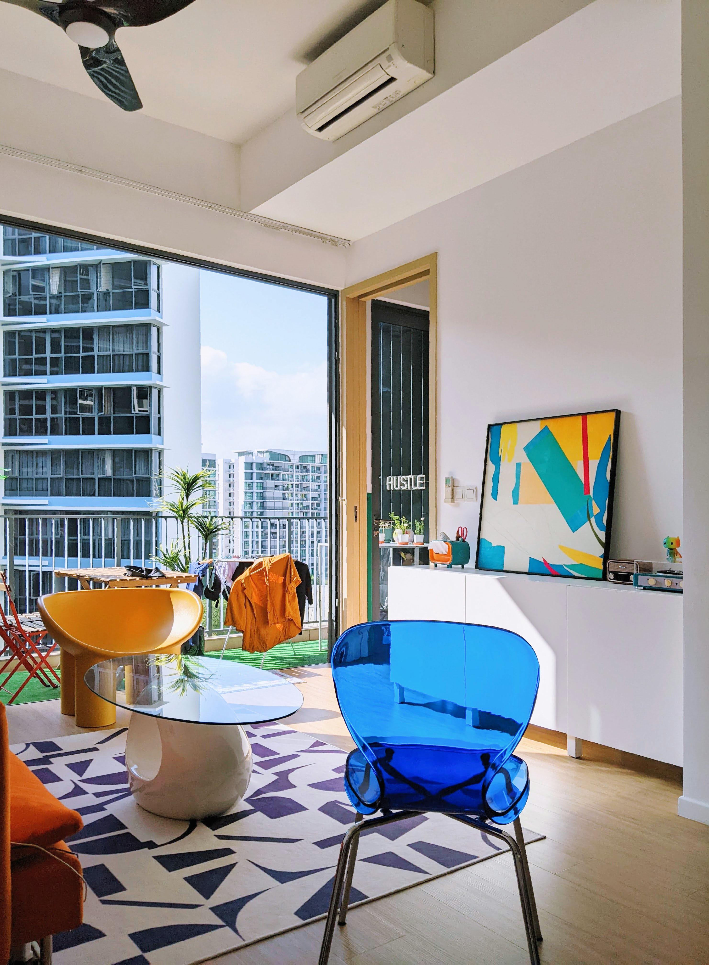 Vibrant Living Room With An Orange Sofa & Yellow Elephant Leg Chair - Modern living room with large glass windows, vibrant