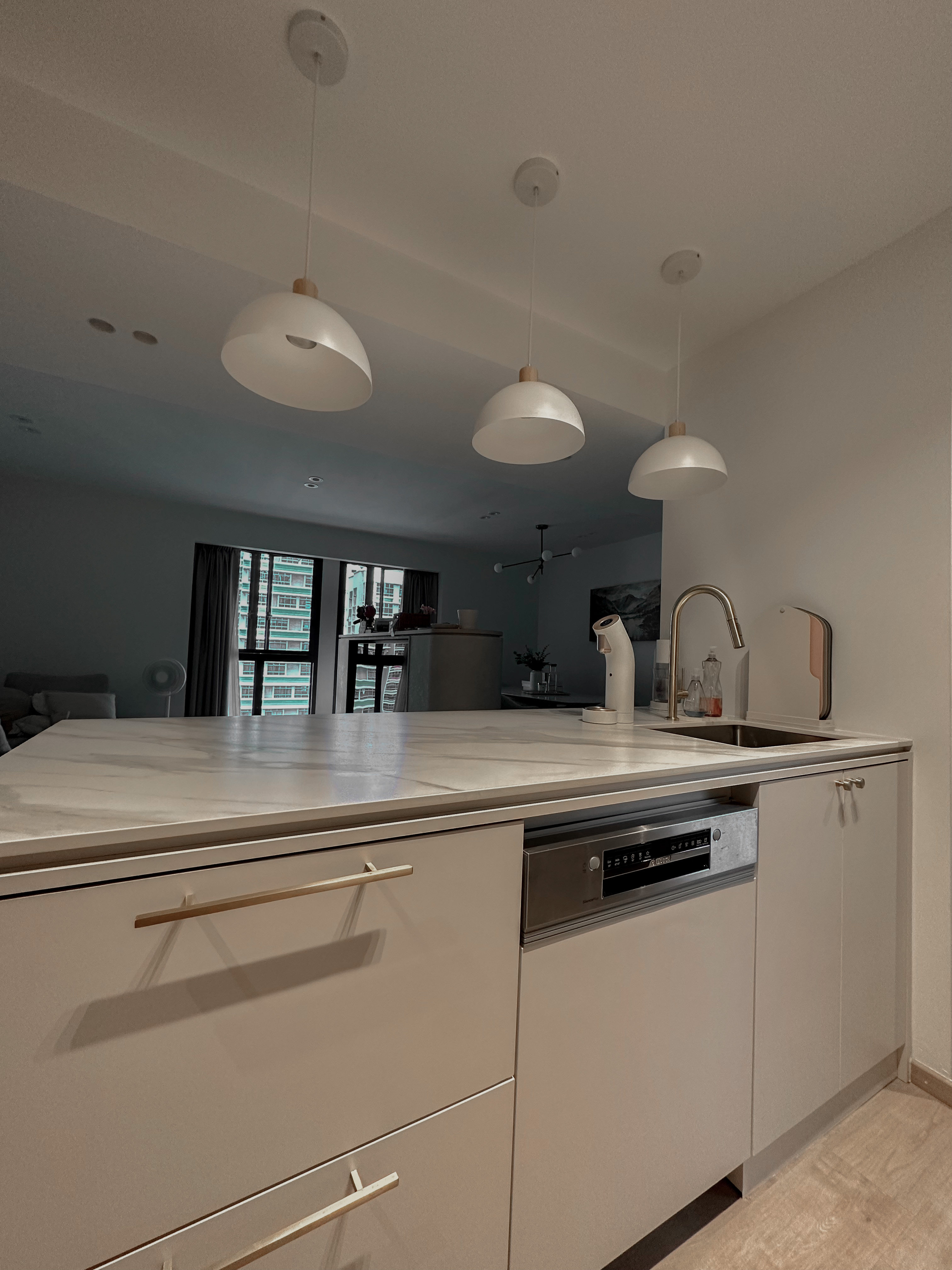 Our Minimalist Open Kitchen - Modern kitchen with marble countertops, sleek white cabinets, minimalist pendant lights, large