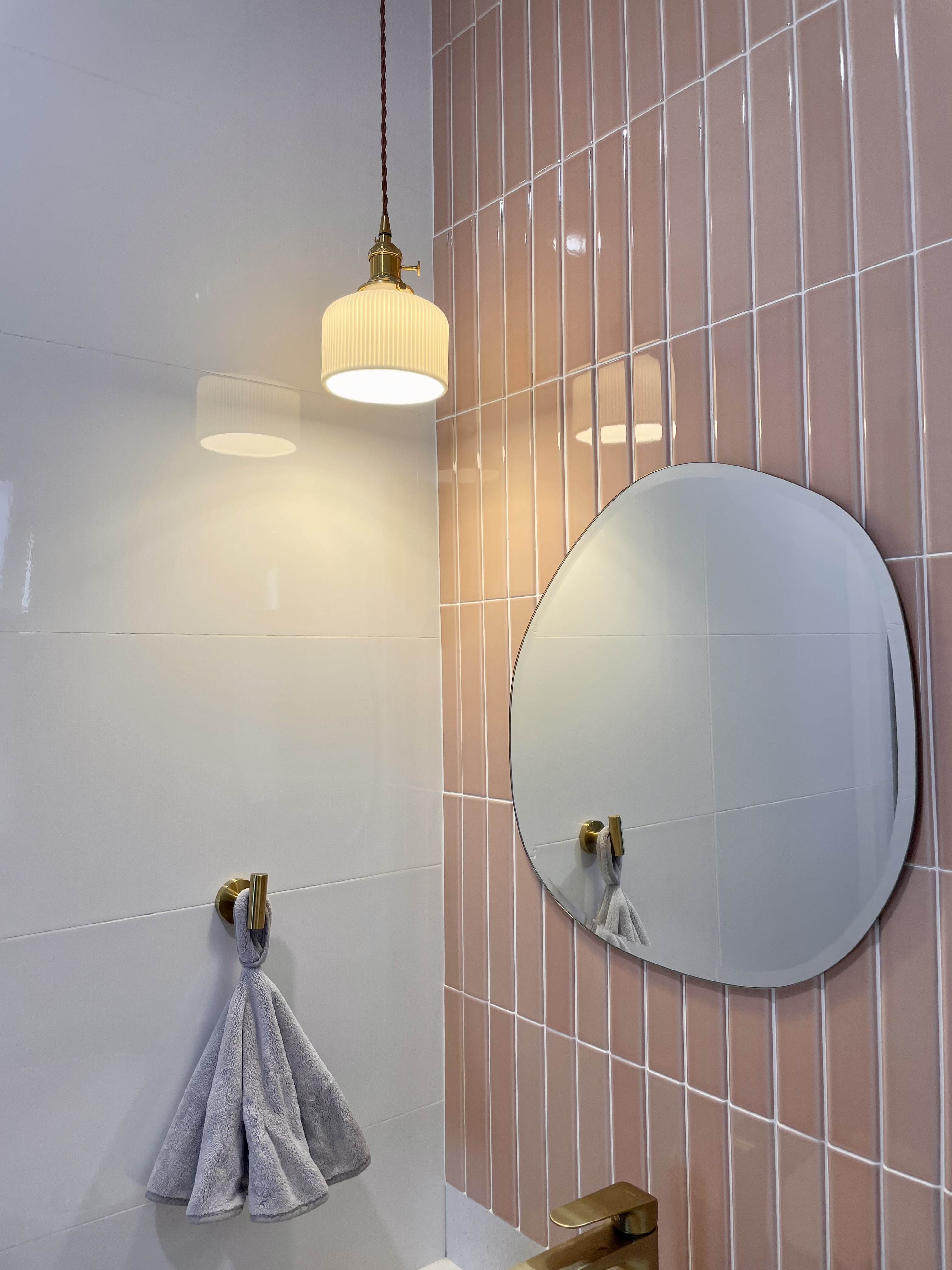 Dream Pink Bathroom without overlaying all walls - White tiled wall, pink tiled wall, round mirror, gold fixtures, light