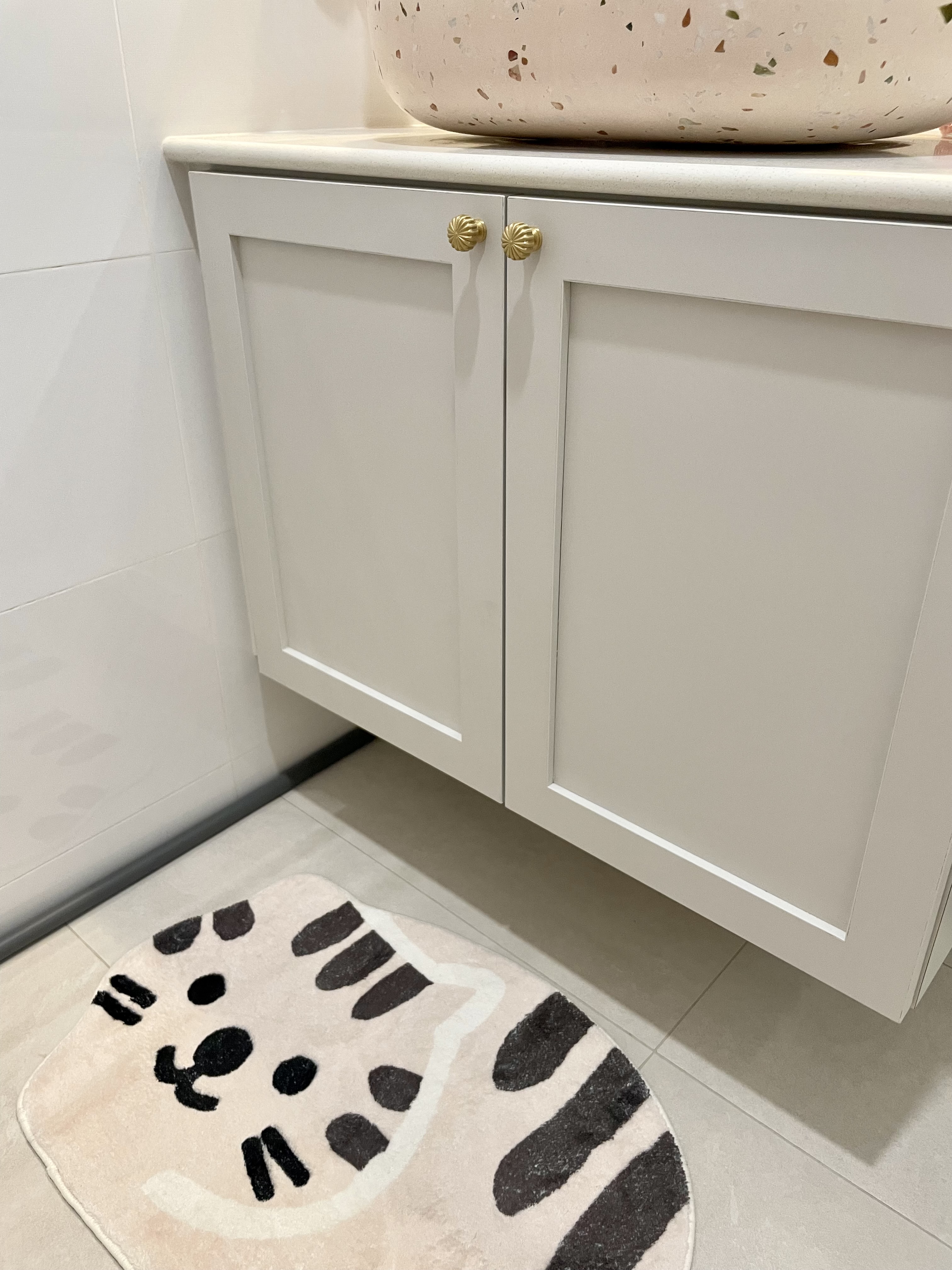 Dream Pink Bathroom without overlaying all walls - White bathroom vanity with gold handles, beige and black cat-patterned