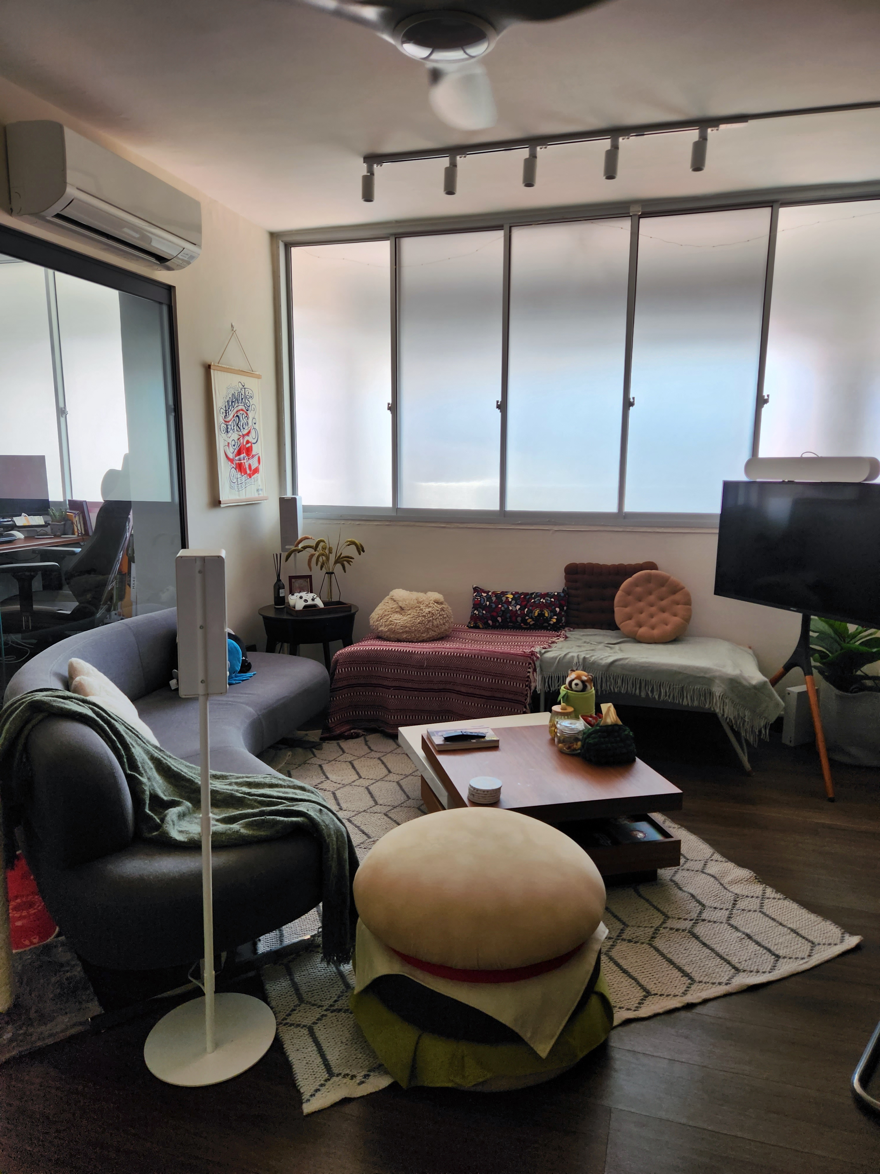 A cosy living space filled with small pops of colour - Modern living room with comfortable seating, large windows, stylish