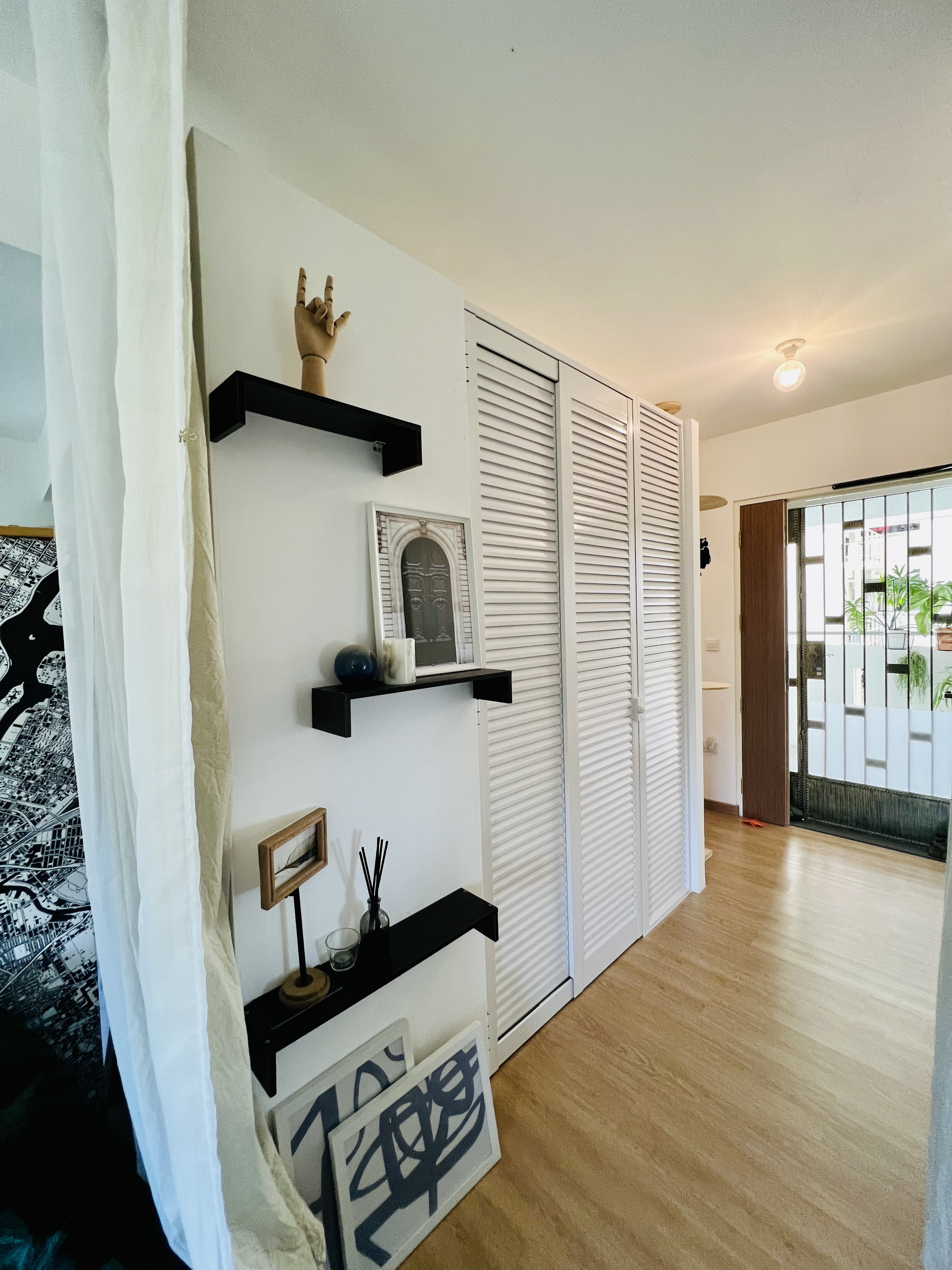 A Maximalist Haven ❤️ - Shelf with abstract art, minimalist decor, white louvered closet doors, black shelves, modern