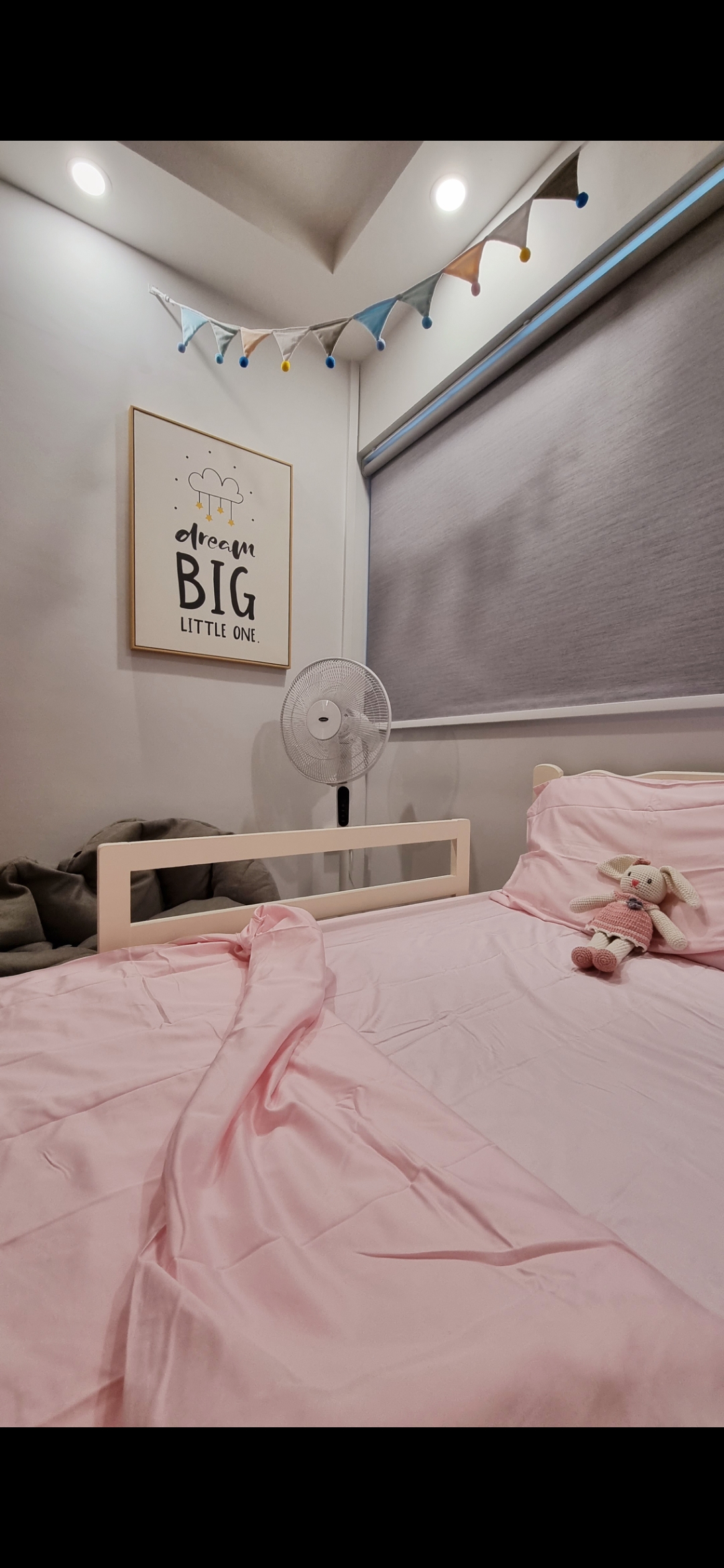 Gender Neutral KIDS bedroom - Soft pink bedding with a cozy bunny toy on the bed, Minimalist bedroom with a single fan and a