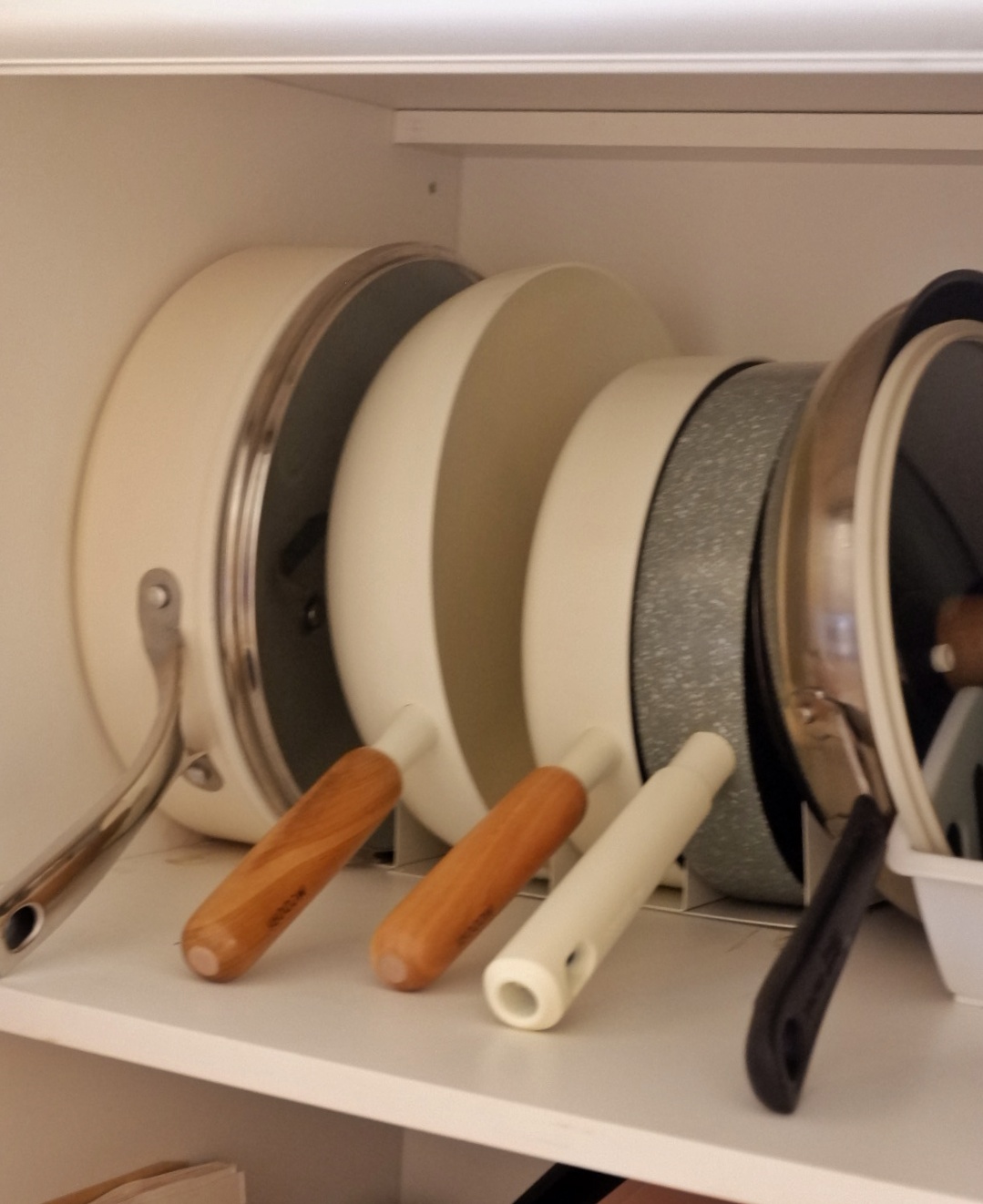 Kitchen organisation  - Silver and white pots, wooden handles, stainless steel pans, black and silver pans, white and silver