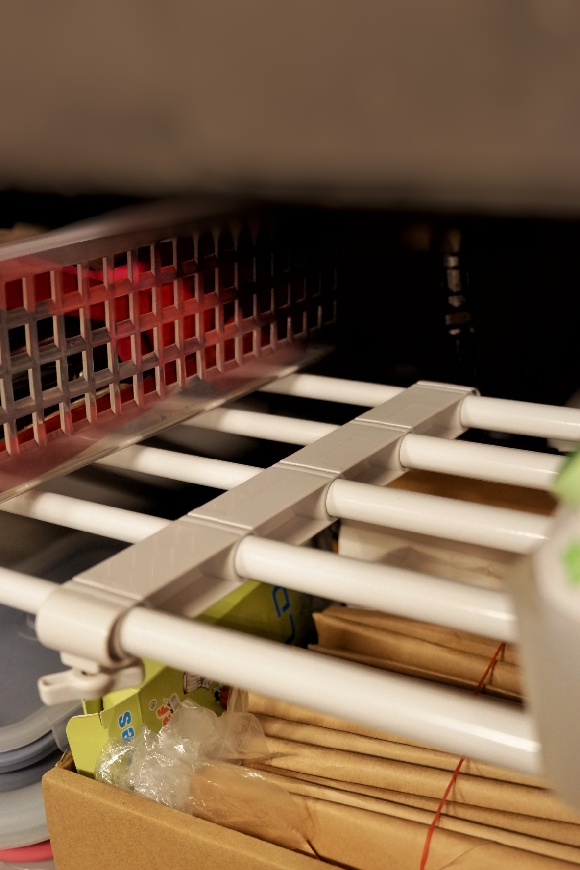 Kitchen organisation  - wire organizer, storage rack, white plastic, metal grid, vertical bars, brown cardboard, brown paper