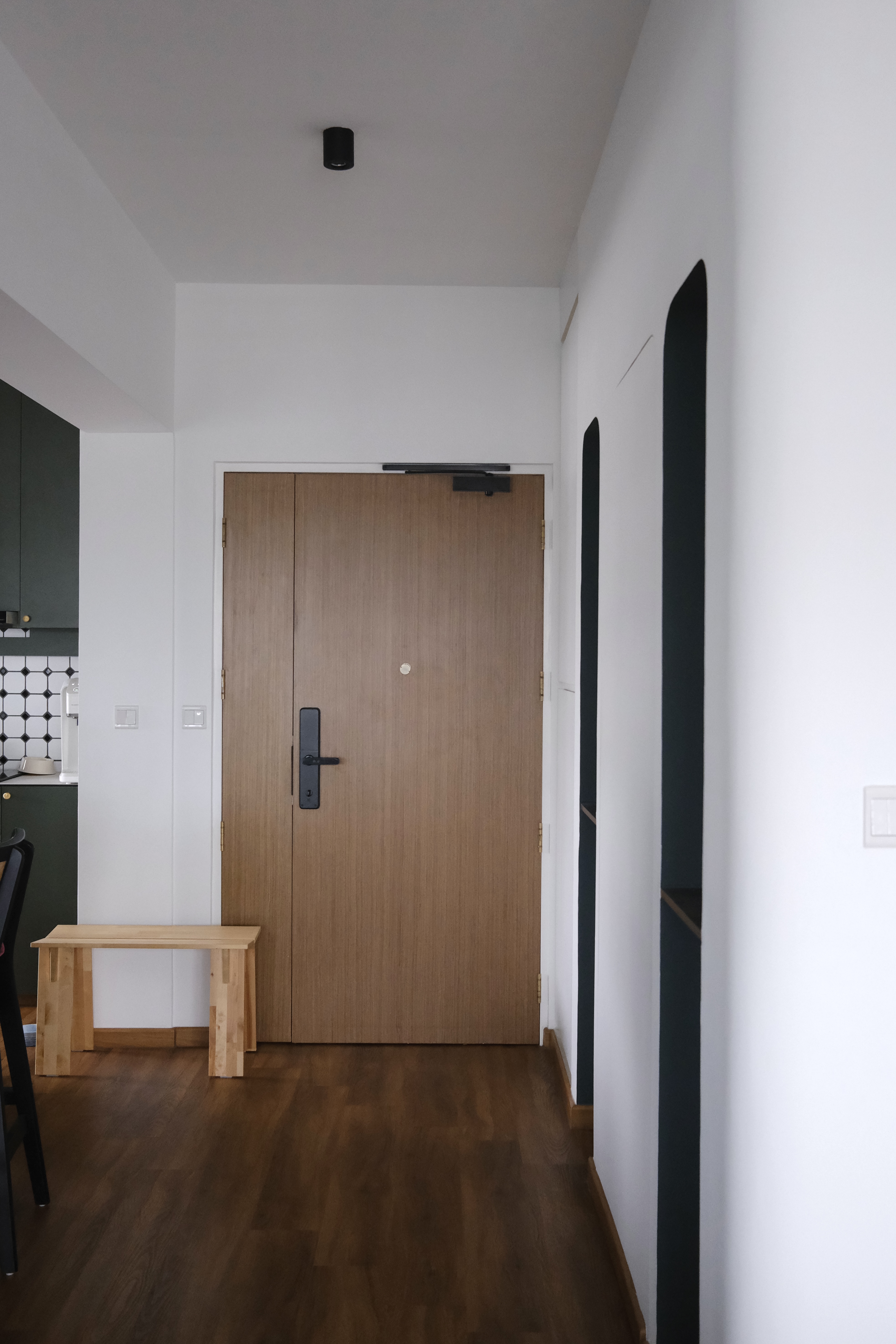 Our Entryway | Where we greet our guests - Modern minimalist kitchen, sleek wooden door, dark green cabinets, white walls