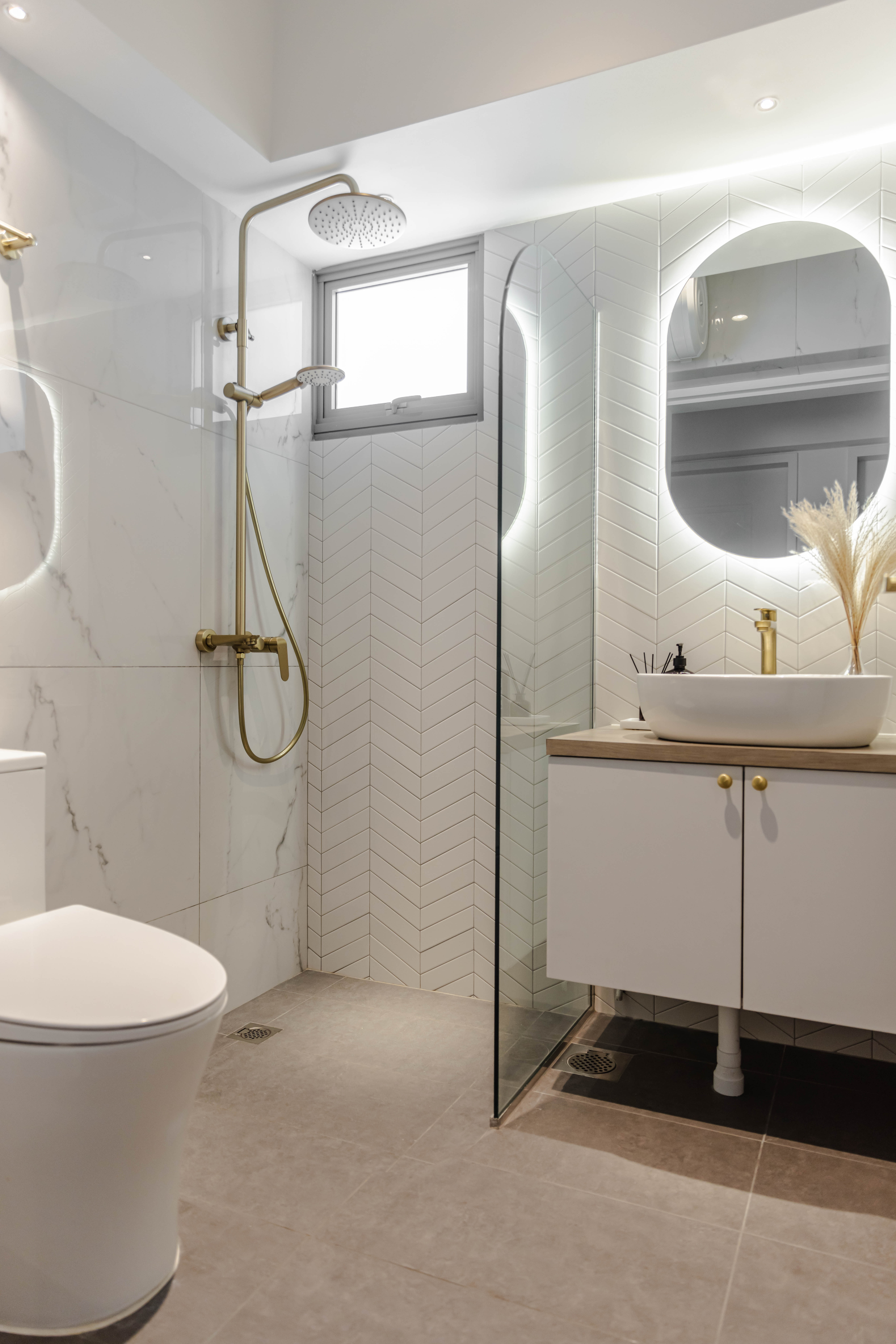 How To Get That Inviting & Luxurious Bathroom Look! - Modern bathroom with sleek design, white marble tiles, gold fixtures