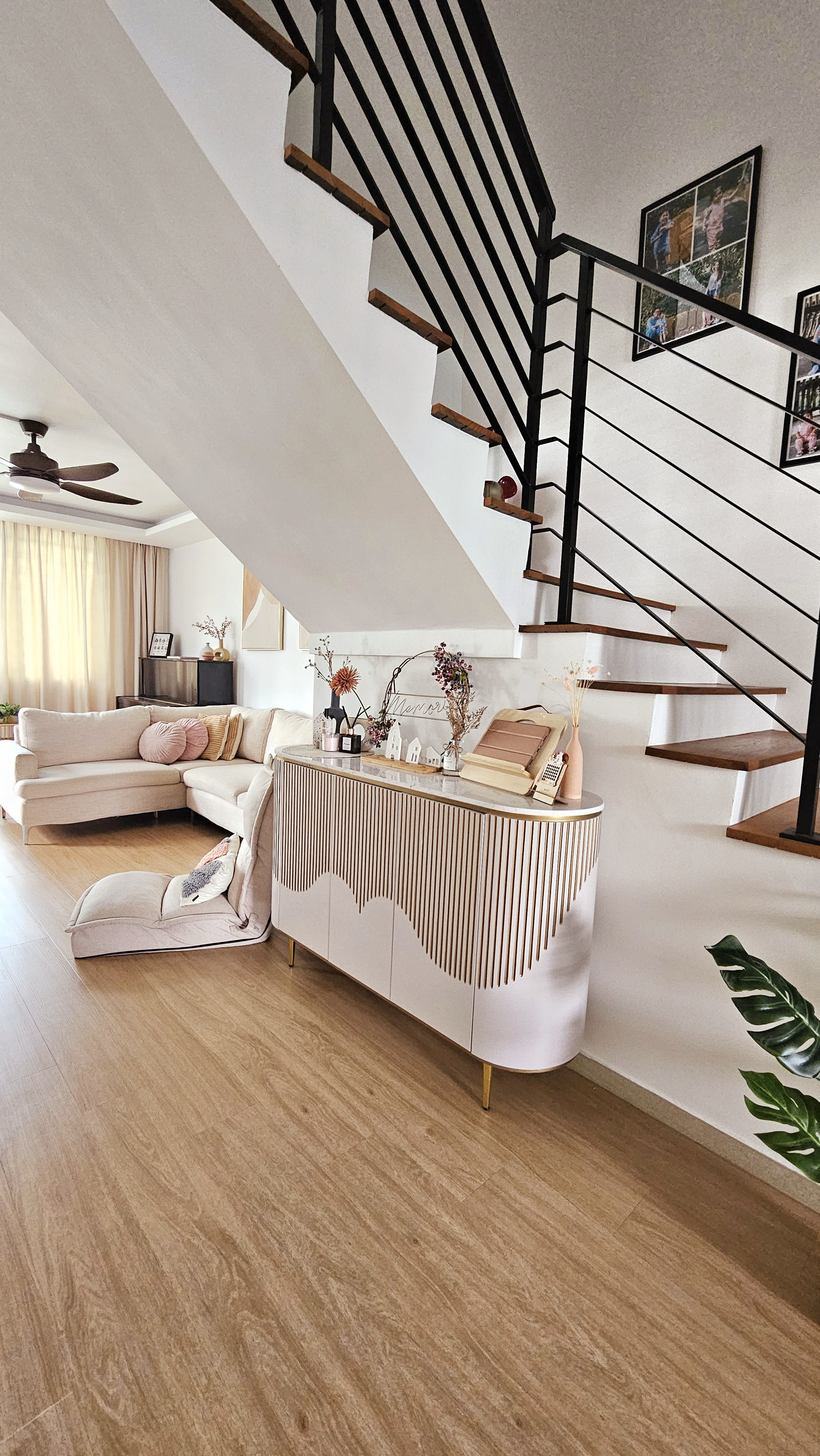 Entryway...or not? - Modern living room with slanted ceiling, beige sofa, decorative pillows, wooden floor, stylish staircase
