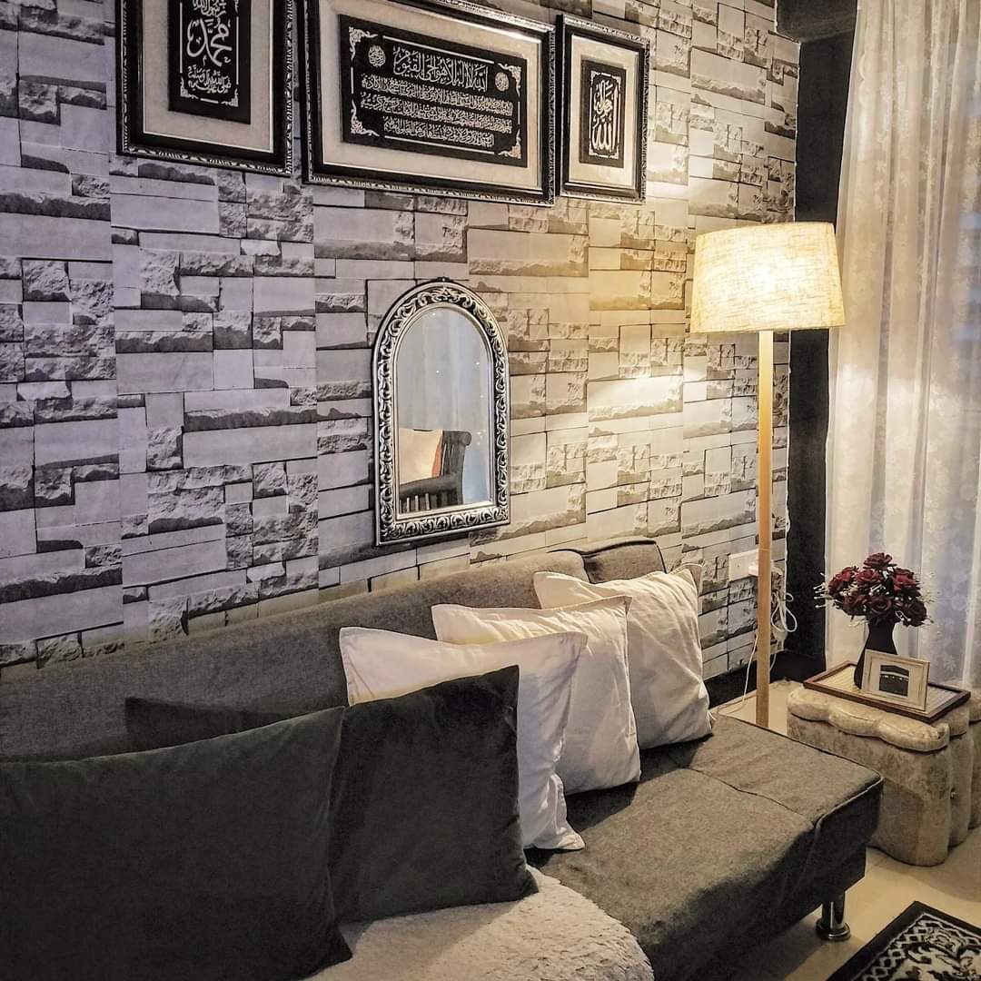 #SGhomestories - Thekilabrets haven👋 - Stone-textured wall, framed Arabic calligraphy, ornate mirror, modern lamp, cozy