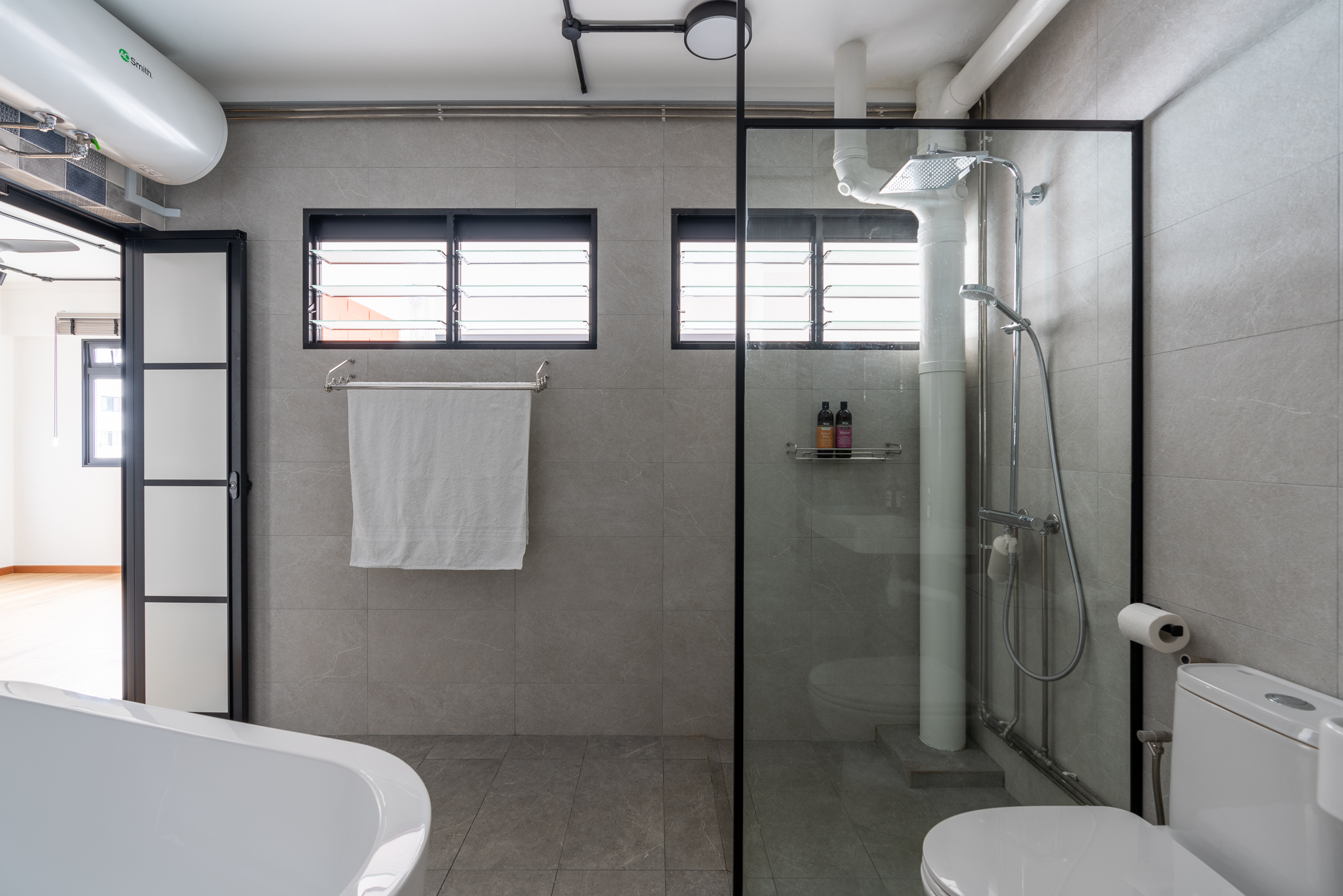 Supersizing Our Bathroom - Modern bathroom with sleek design, gray tiles, two windows with horizontal blinds, glass shower