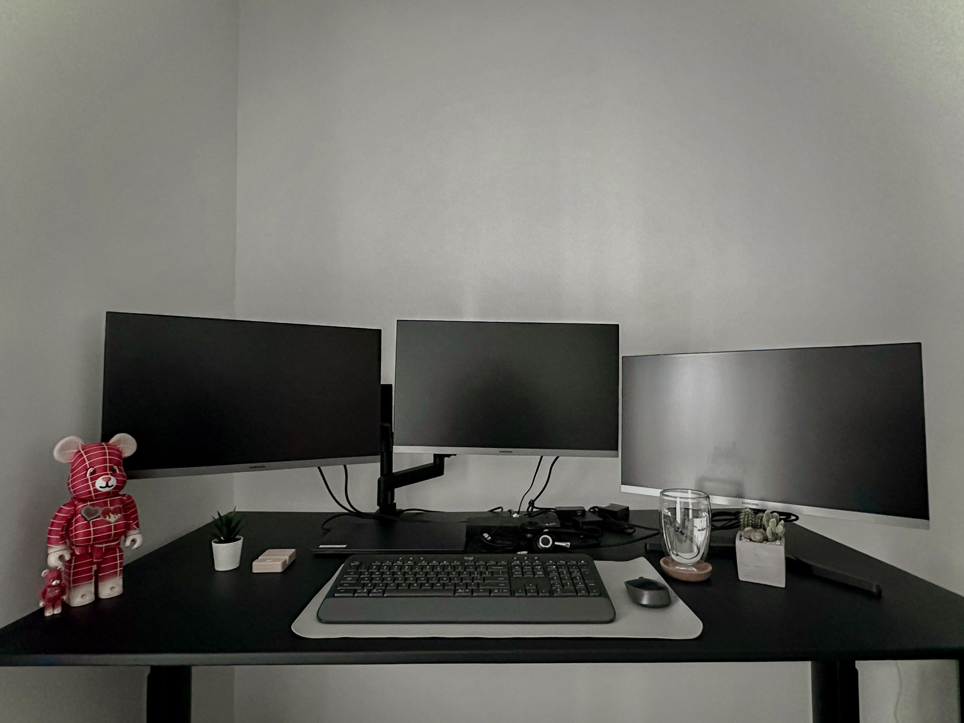 His & Hers Study Deskfie | Simplicity is The Way - Black desk with three monitors, ergonomic keyboard and mouse, red teddy