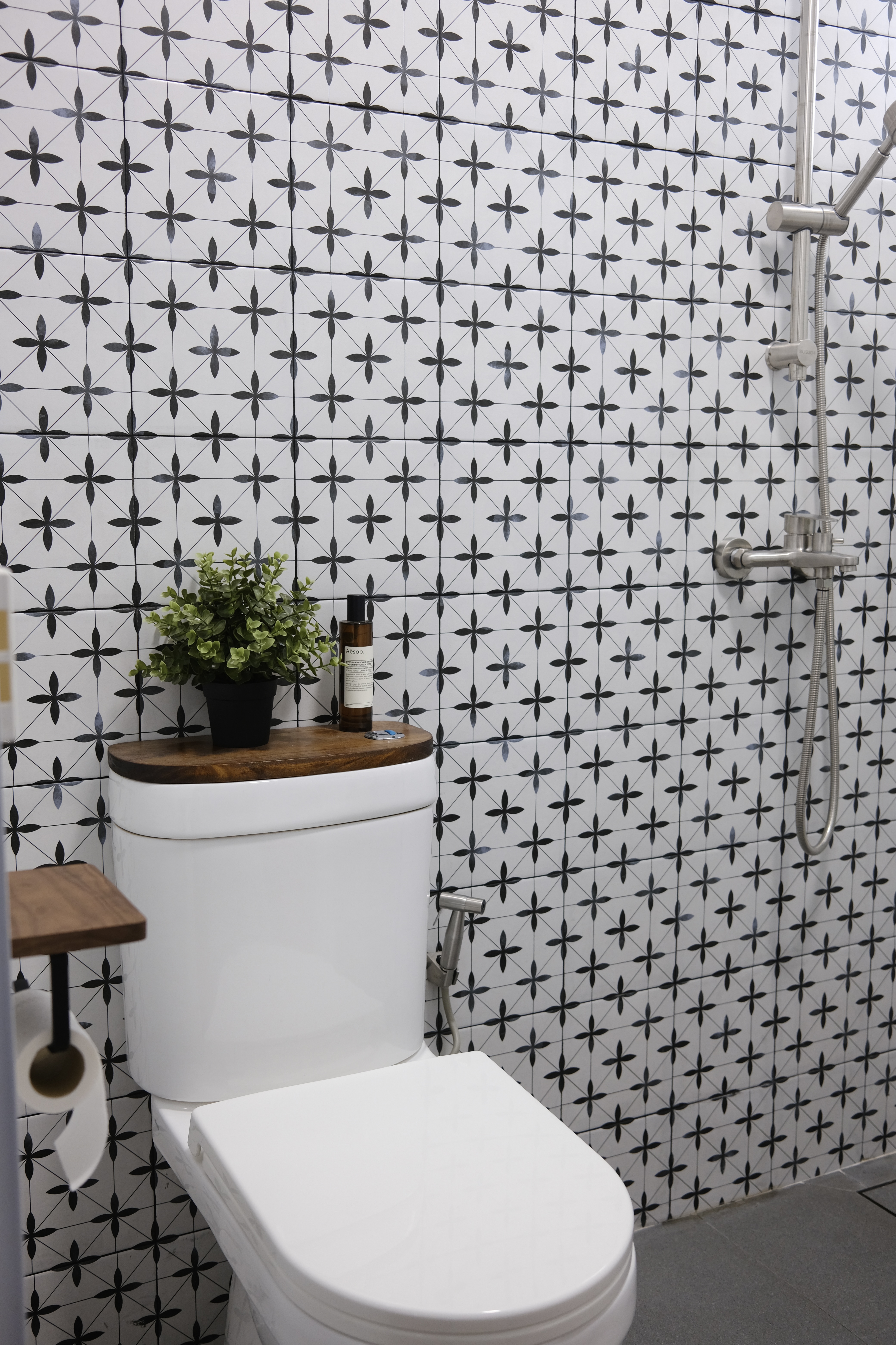 Adding Greens | Where we add the small touches - Patterned tiles, white toilet, wooden shelf, green plant, black and white