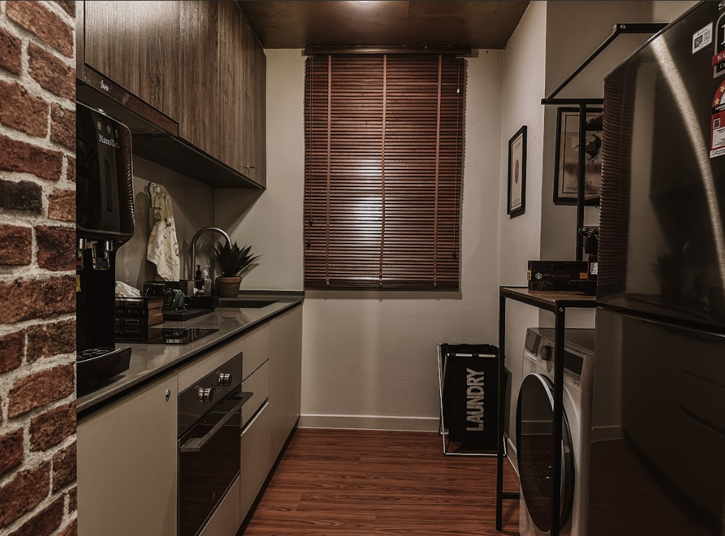 A Magical Harry Potter Haven - Modern kitchen with brick wall, stainless steel appliances, wooden cabinets, black countertop