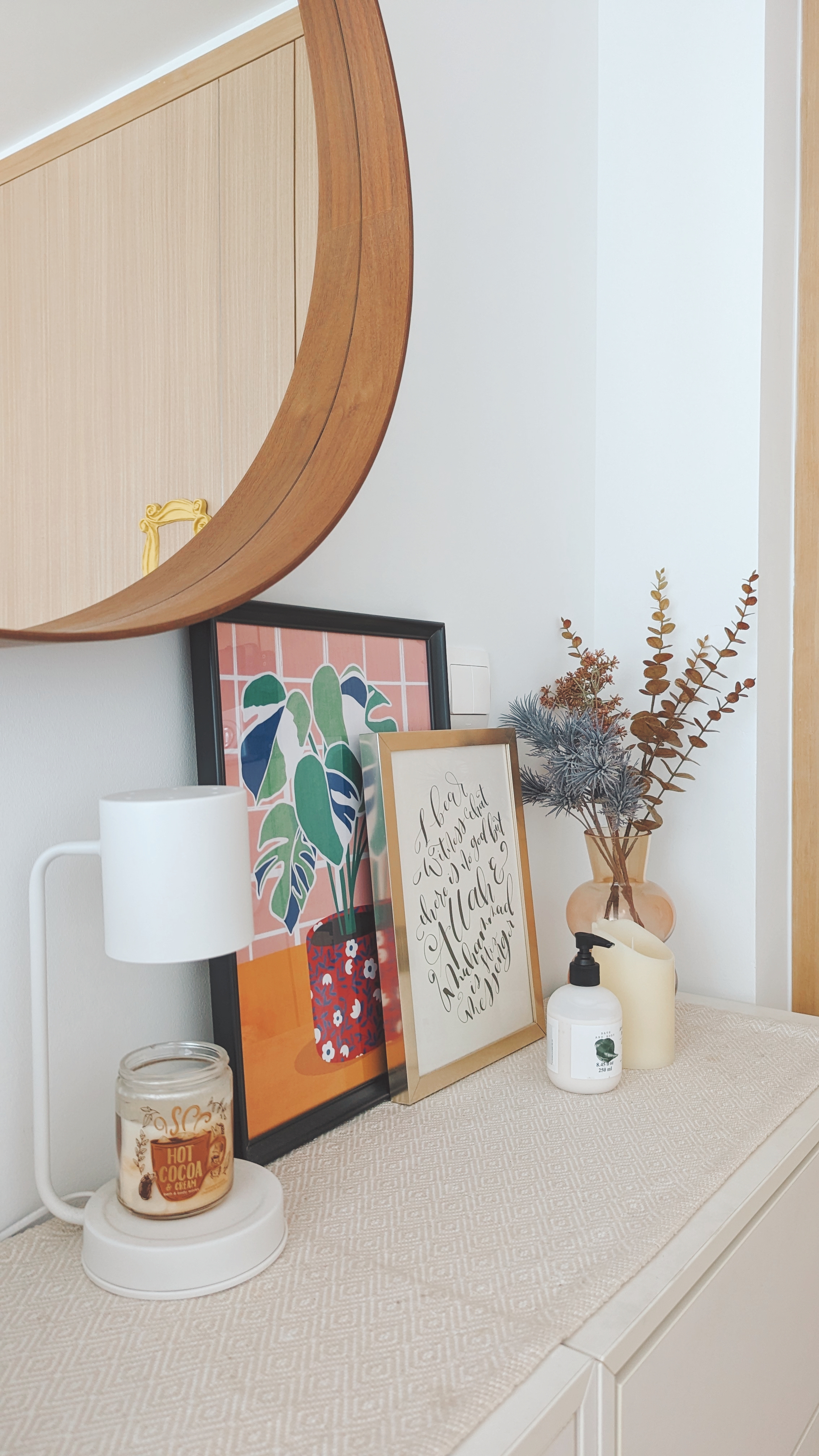 Walk about our quirky, catto-loving space. - Wooden cabinet, mirror, gold handle, white lamp, framed picture, abstract art