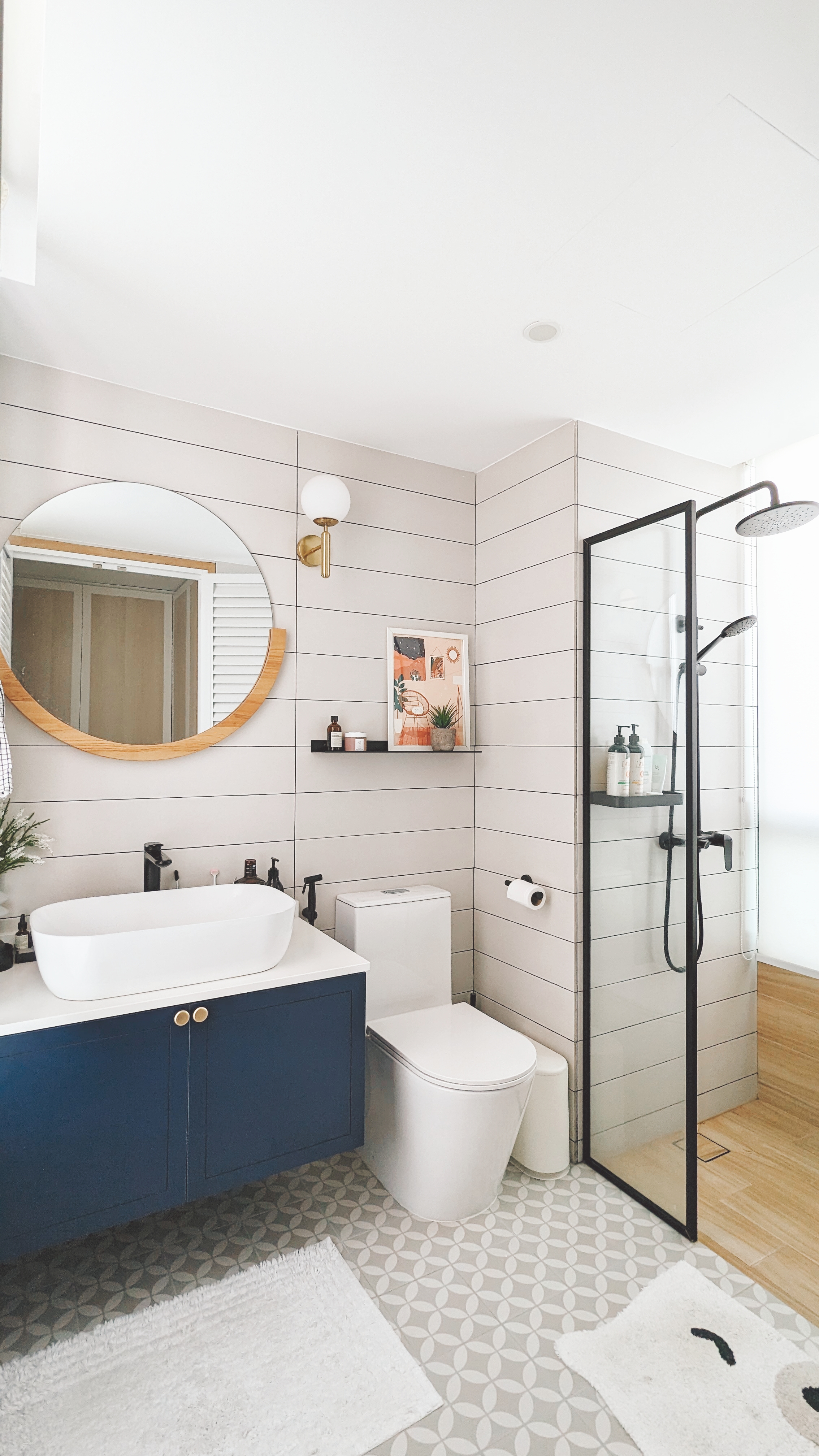 Walk about our quirky, catto-loving space. - Modern bathroom with sleek design, white and blue color scheme, round mirror