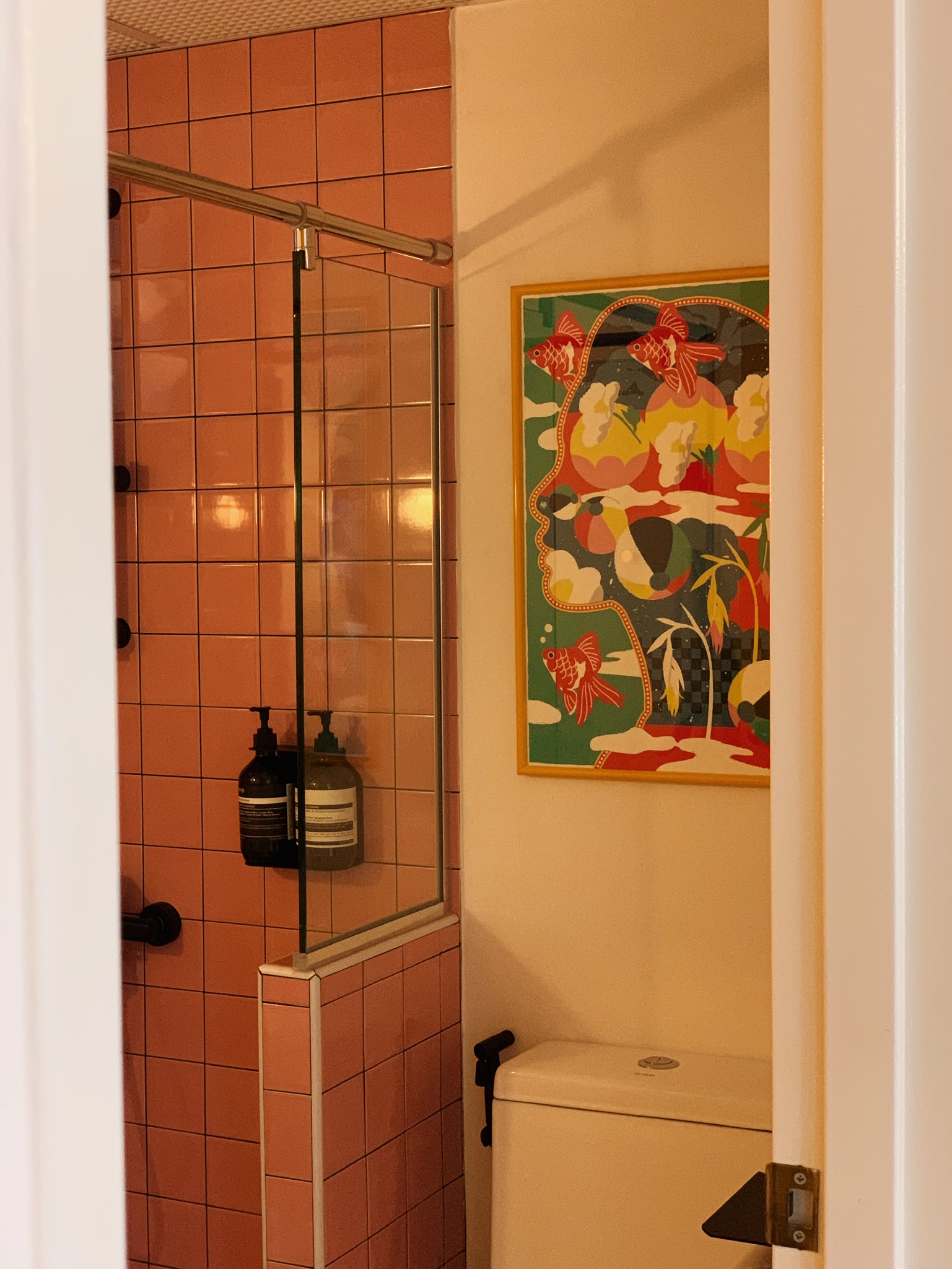 Where Every Bathroom Break is a Mini Getaway! - Pink tiled shower enclosure, black shower controls, glass shower door, soap