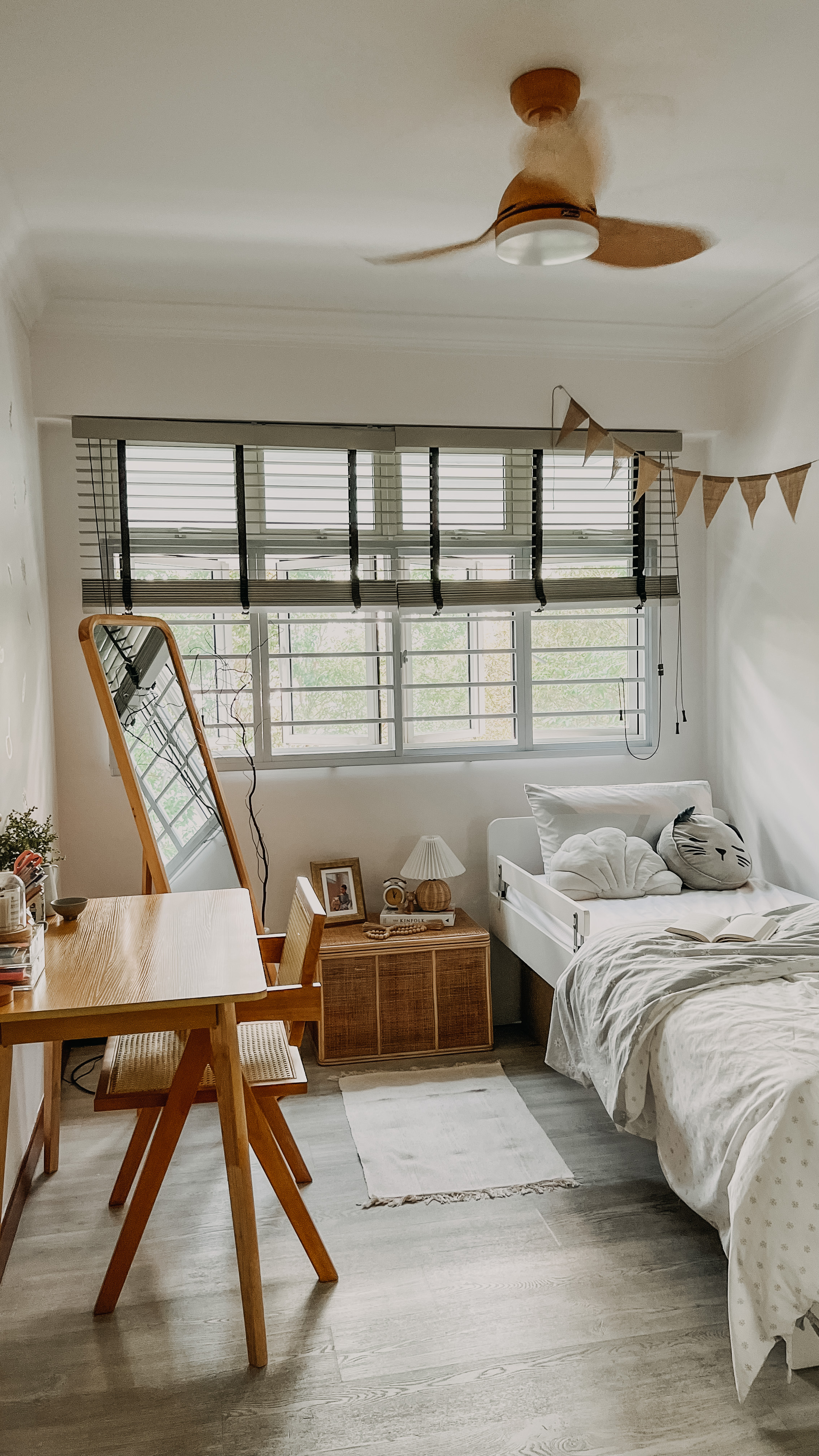 Kids Bedroom - Wooden desk, white bed, fluffy pillows, open book, woven rug, wooden chair, striped pillow, framed photo