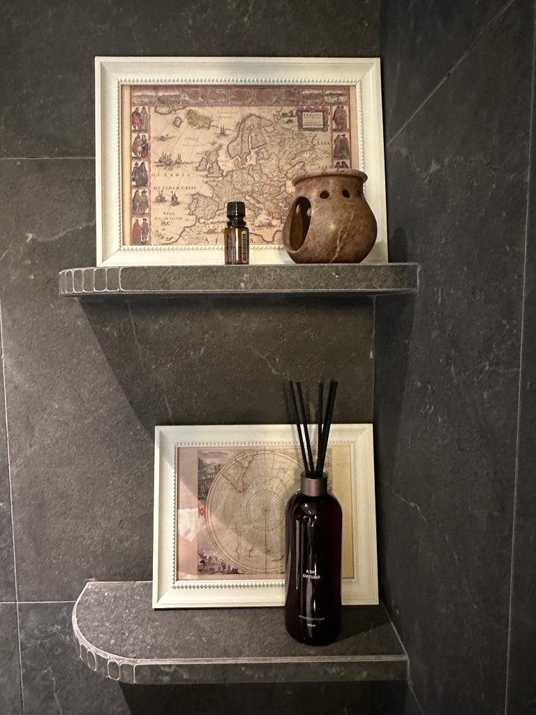 Immerse your senses in a dark and relaxing bathroom - Elegant shelf display, vintage map, ornate frame, antique vase, scented