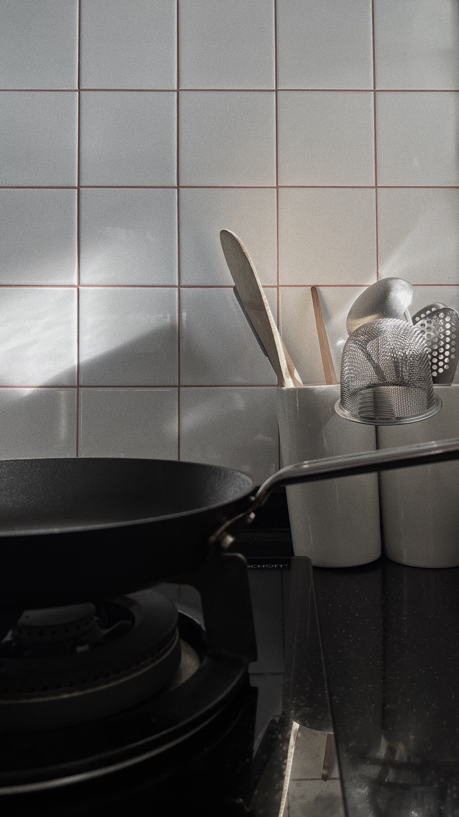Revitalizing Our Kitchen: Tile Transformation & Custom Handles - black frying pan, white tiled wall, kitchen utensils, wooden