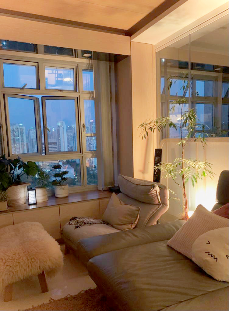 Light Up The Plant | Cosy Corner  - Modern living room, cozy seating area, large windows, cityscape view, indoor plants, warm