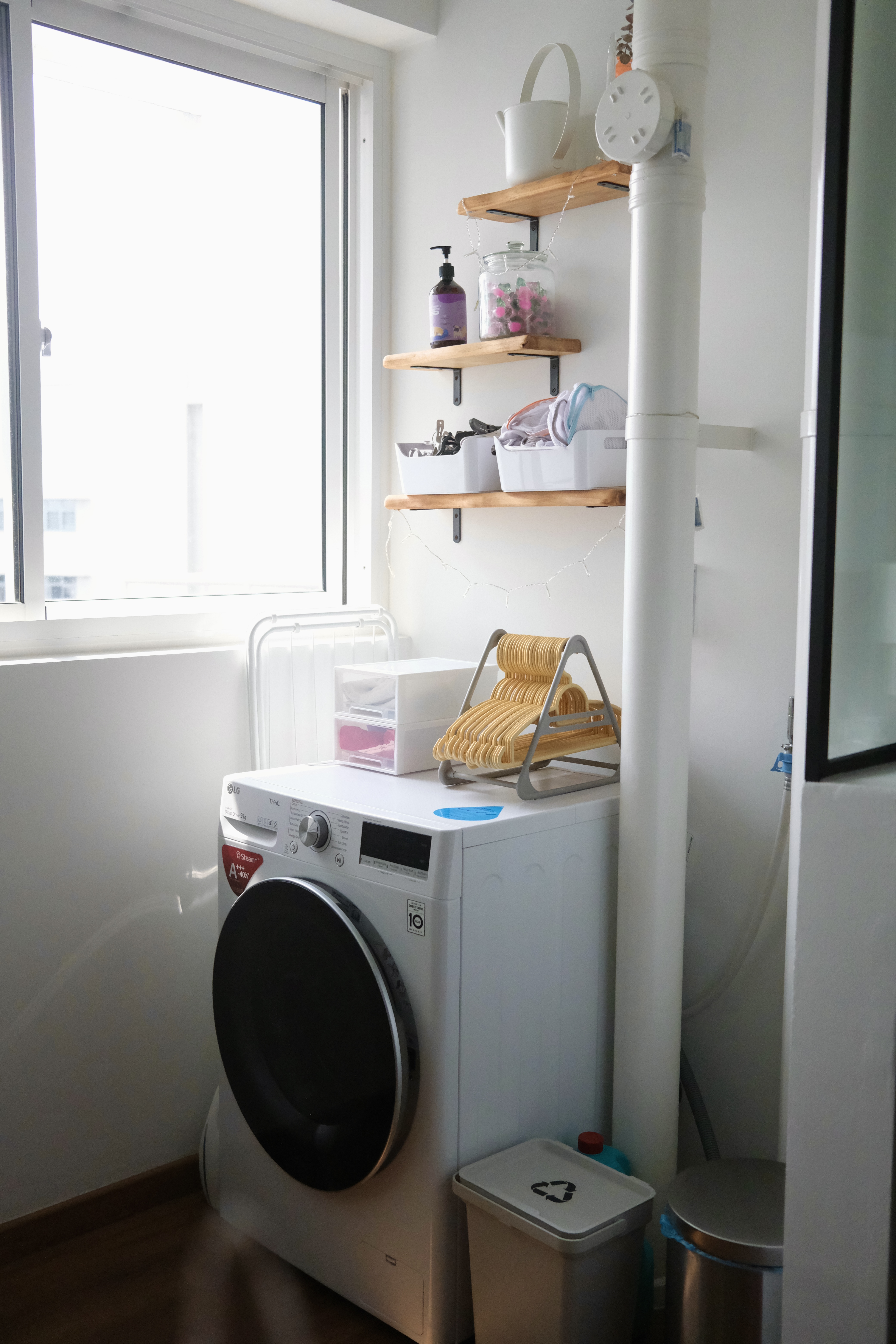 The Service Yard | An extension of our kitchen - Shower area with washing machine, wooden shelves with various items, laundry