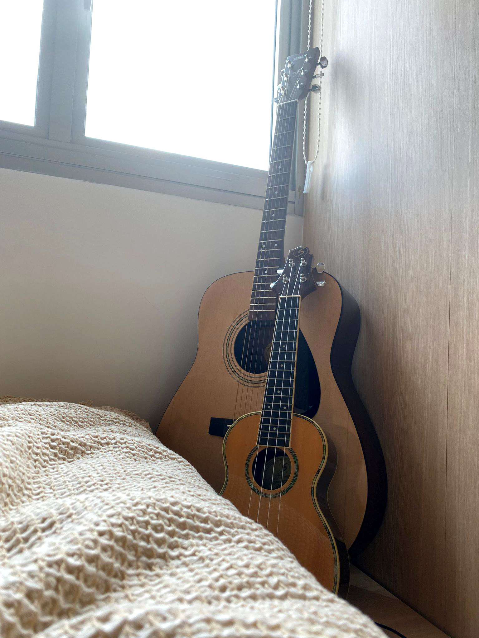 Teenage Room | Japanese Inspired Interior - Guitar leaning against wall, wooden floor, beige textured blanket, window with