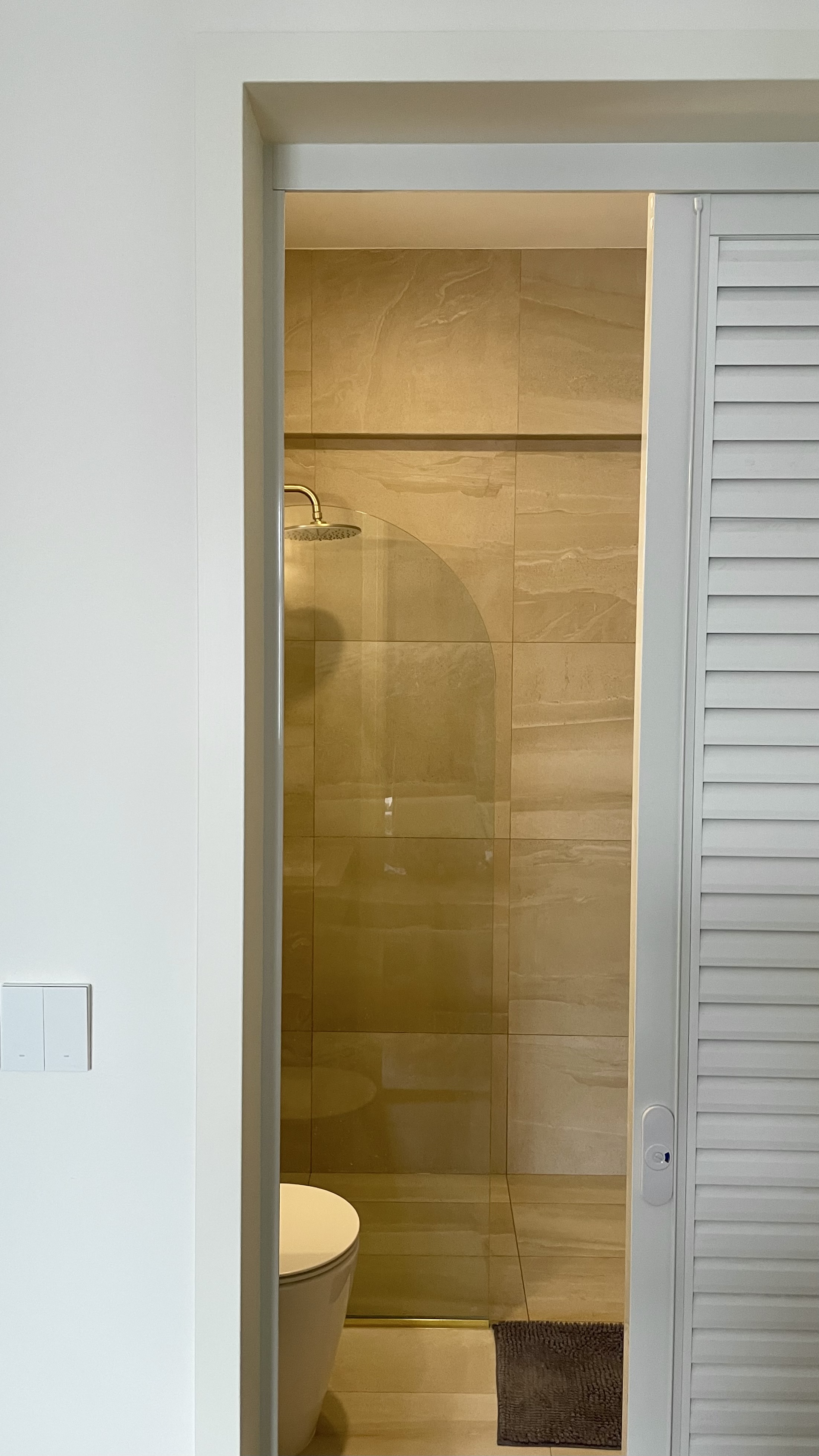 Travertine Hotel Bathroom in BTO - Modern bathroom, minimalist design, sleek fixtures, glass shower enclosure, beige tiles