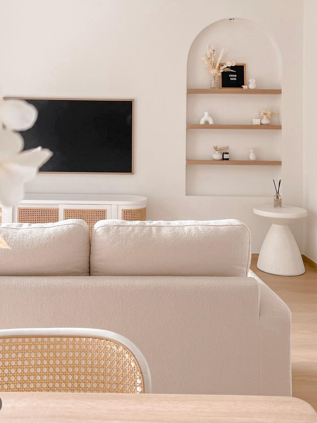 Bright and airy kids friendly home with lots of curves - Cream-colored sofa, minimalist decor, soft lighting, modern art