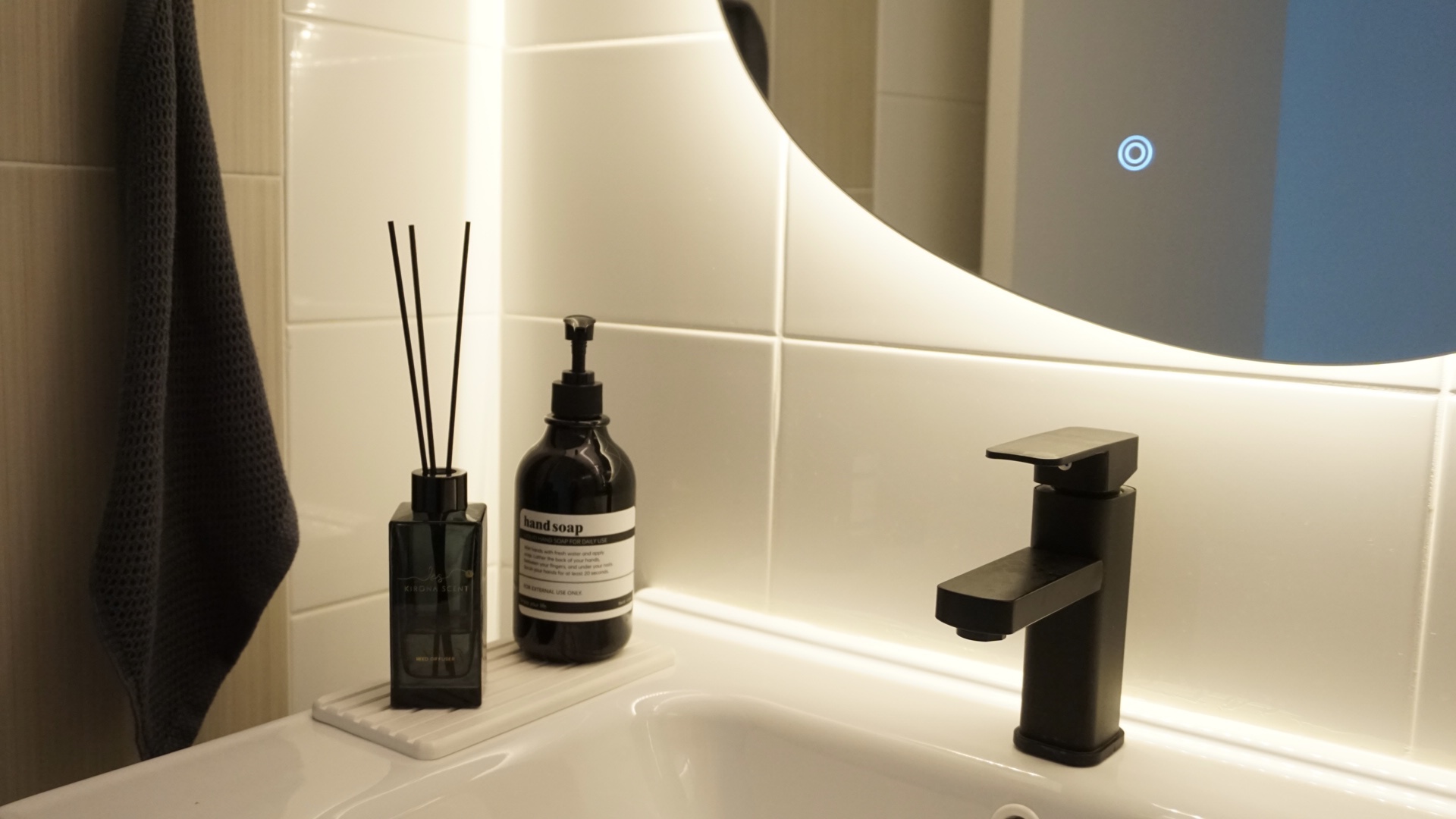 Creating our abode on cloud9, without an ID.  - dark gray textured towel, white tiled wall, modern bathroom, black soap