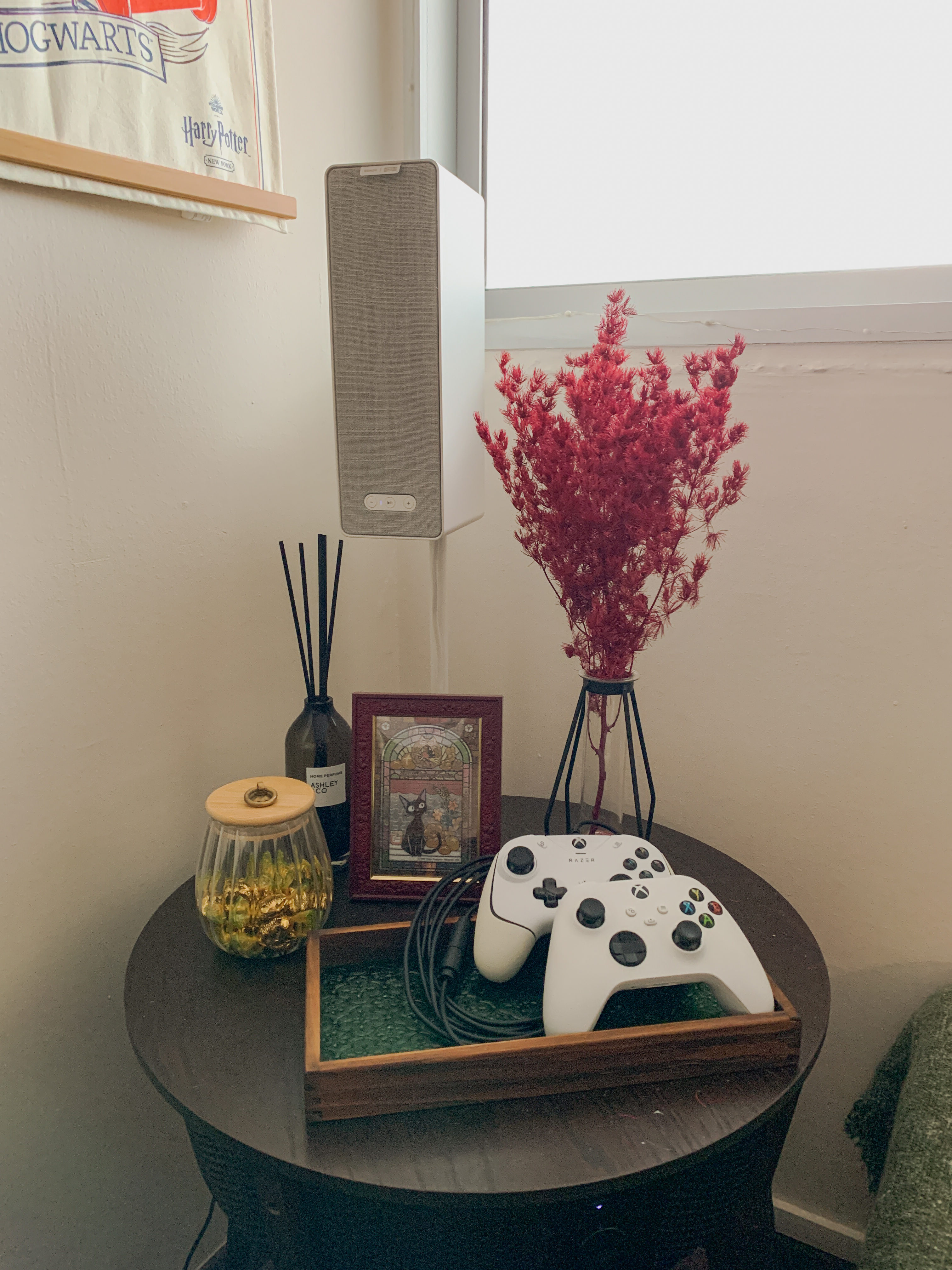 Styling a Cosy Corner for an Autumnal Mood - vibrant red decorative plant, modern white speaker, textured gray fabric, small