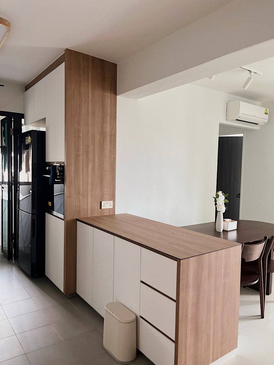 Mid-modern century with hand-me-down built-ins - Wooden kitchen cabinets, sleek refrigerator, black and white appliances