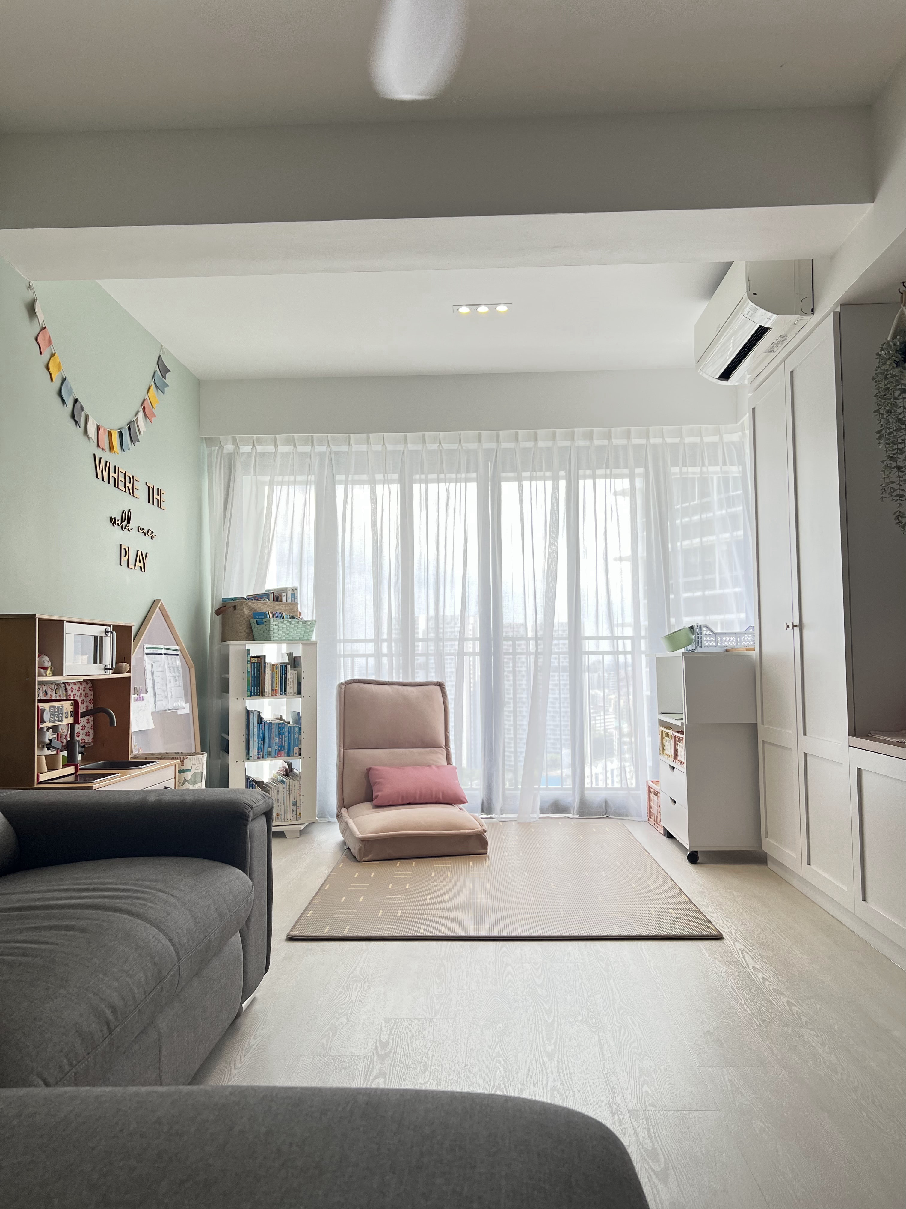 Welcome to our Open Concept Kids Friendly Home  - Light green wall, white ceiling, hanging bunting, "Where the will play"