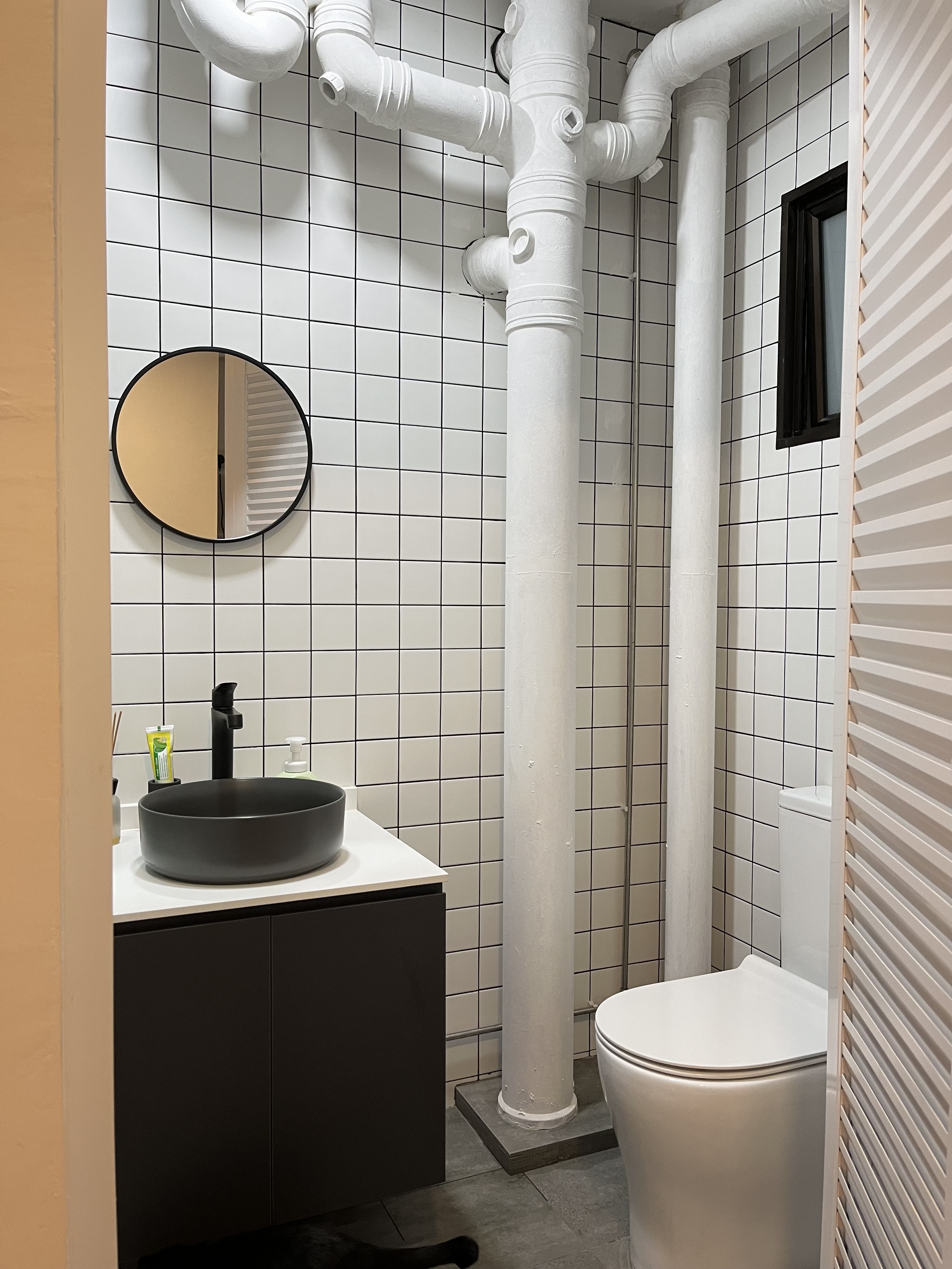 Home Sweet Kindercore - Where Fun Meets Comfort - modern bathroom, tiled wall, white tiles, black countertop, round mirror