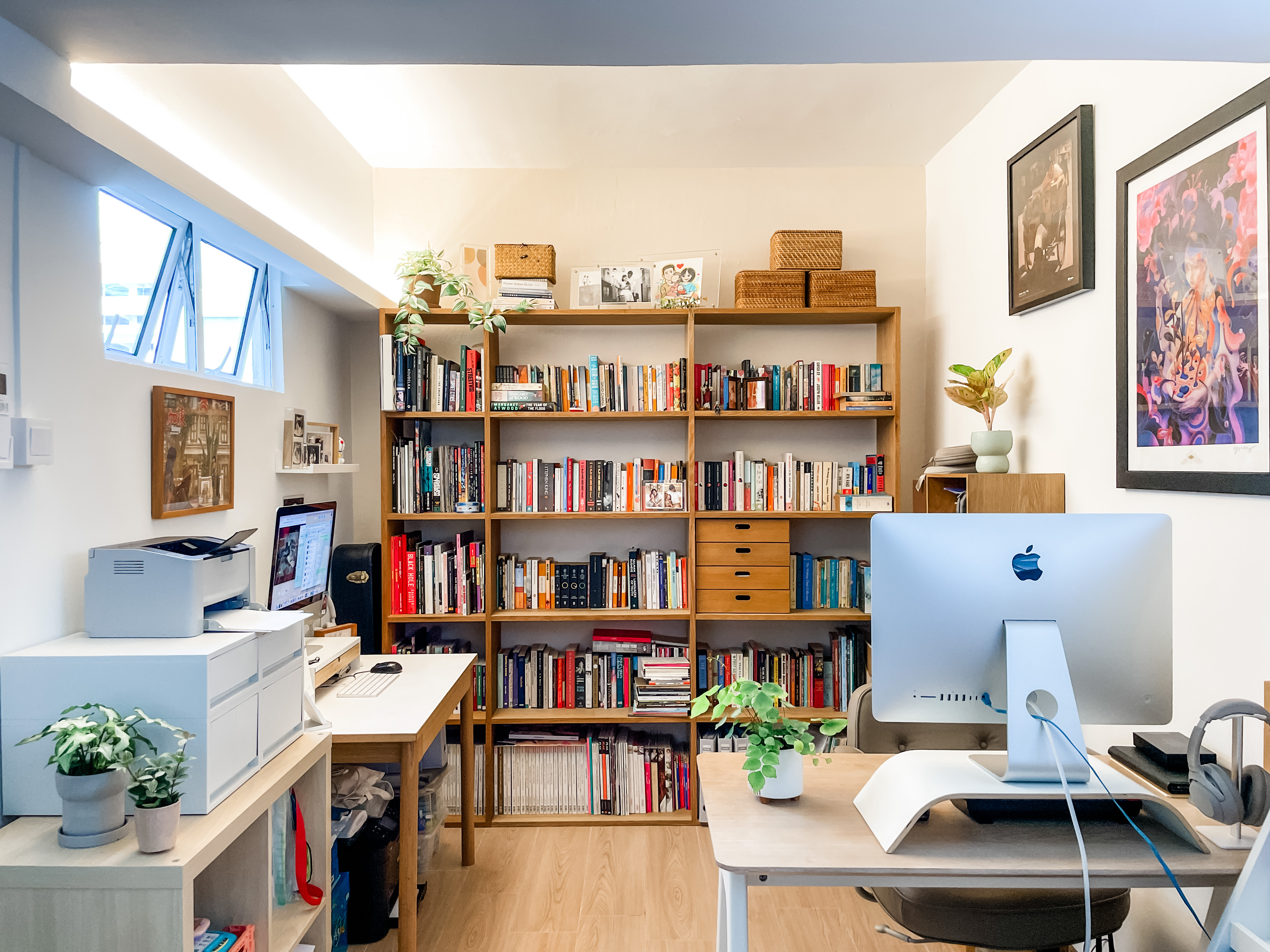 Light-filled, Open-plan Scandi Executive Apartment - Wooden bookshelf filled with books, framed artwork, potted plants, desk