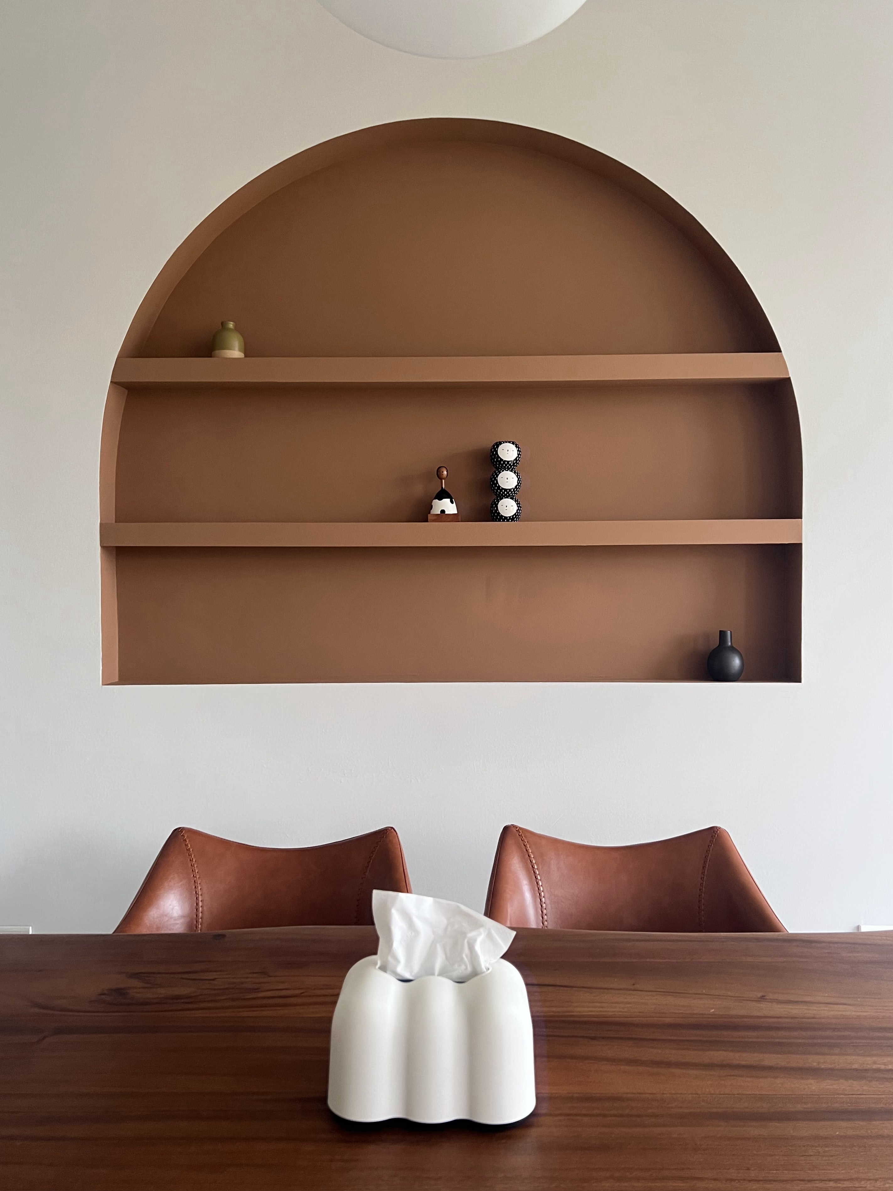 From Blank Canvas to Cosy Haven - Brown arched shelving unit, minimalist design, wooden table, leather chairs, white tissue