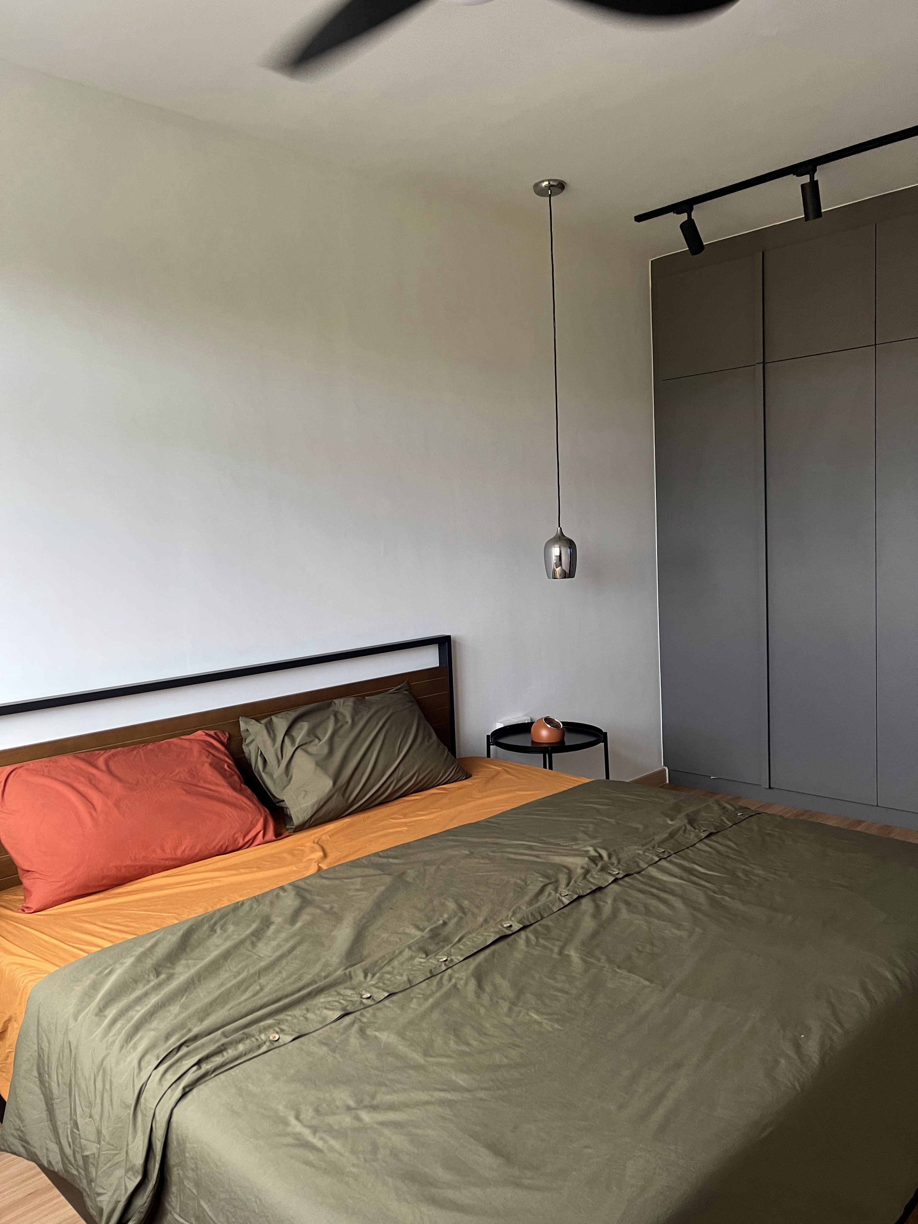 From Blank Canvas to Cosy Haven - Modern minimalist bedroom, neutral color palette, large bed with orange and green bedding