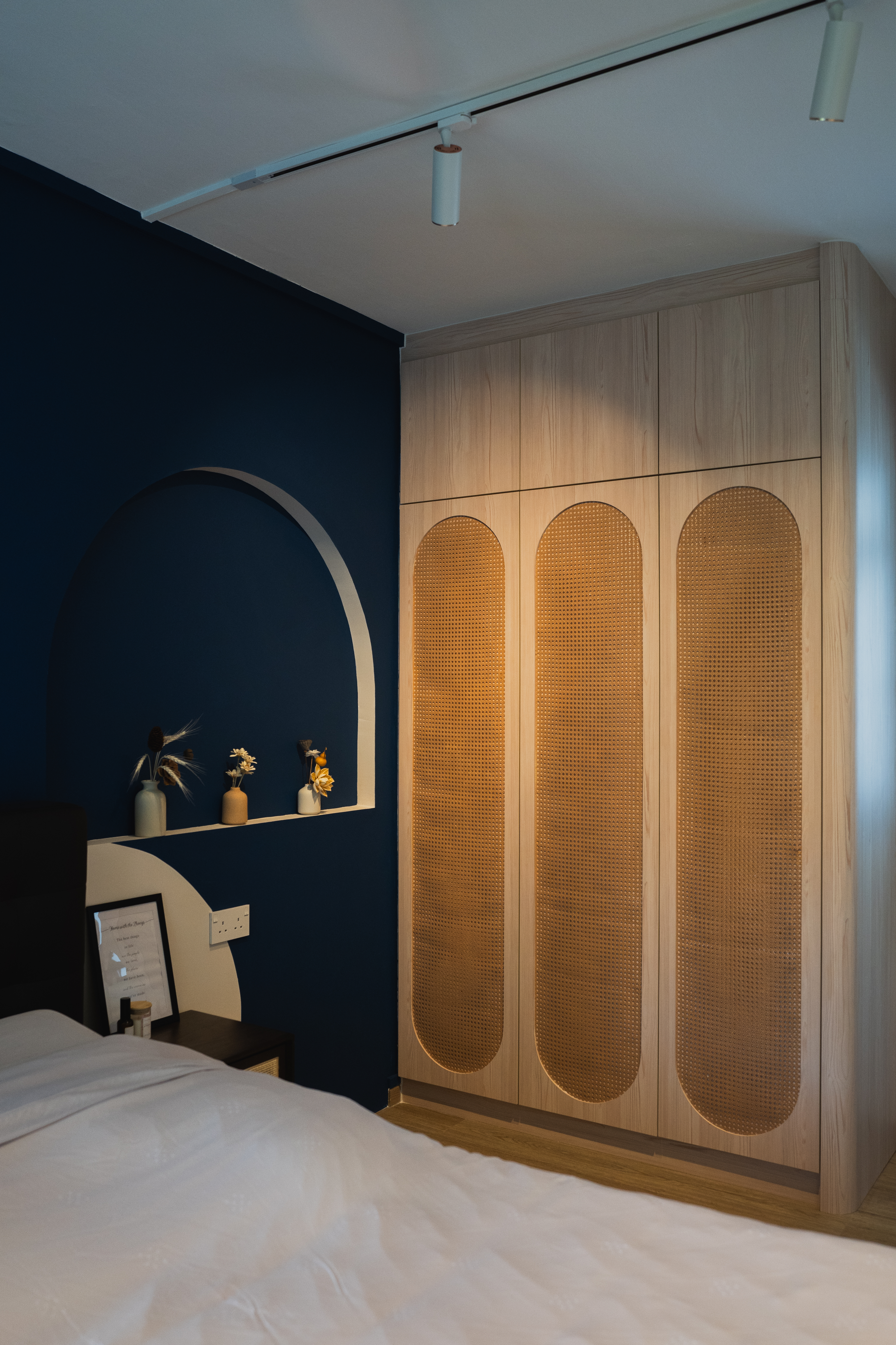 Italian cafe inspired theme  - Dark blue wall, wooden wardrobe, arched shelf, decorative vases, natural light, modern design