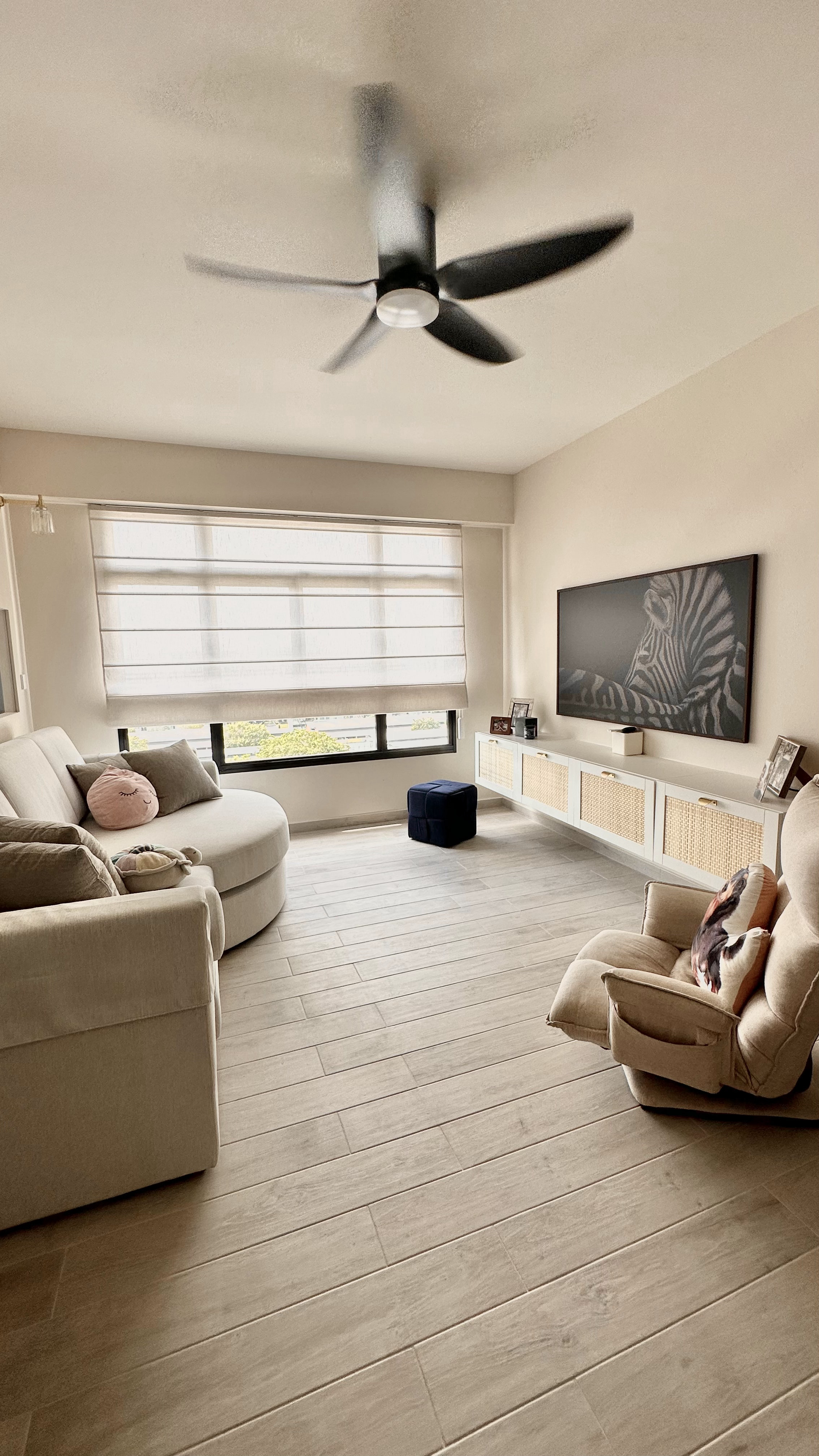 Welcome to oureastsideflat! ✨ - Cream-colored living room, modern ceiling fan, large window with blinds, beige sofa, plush