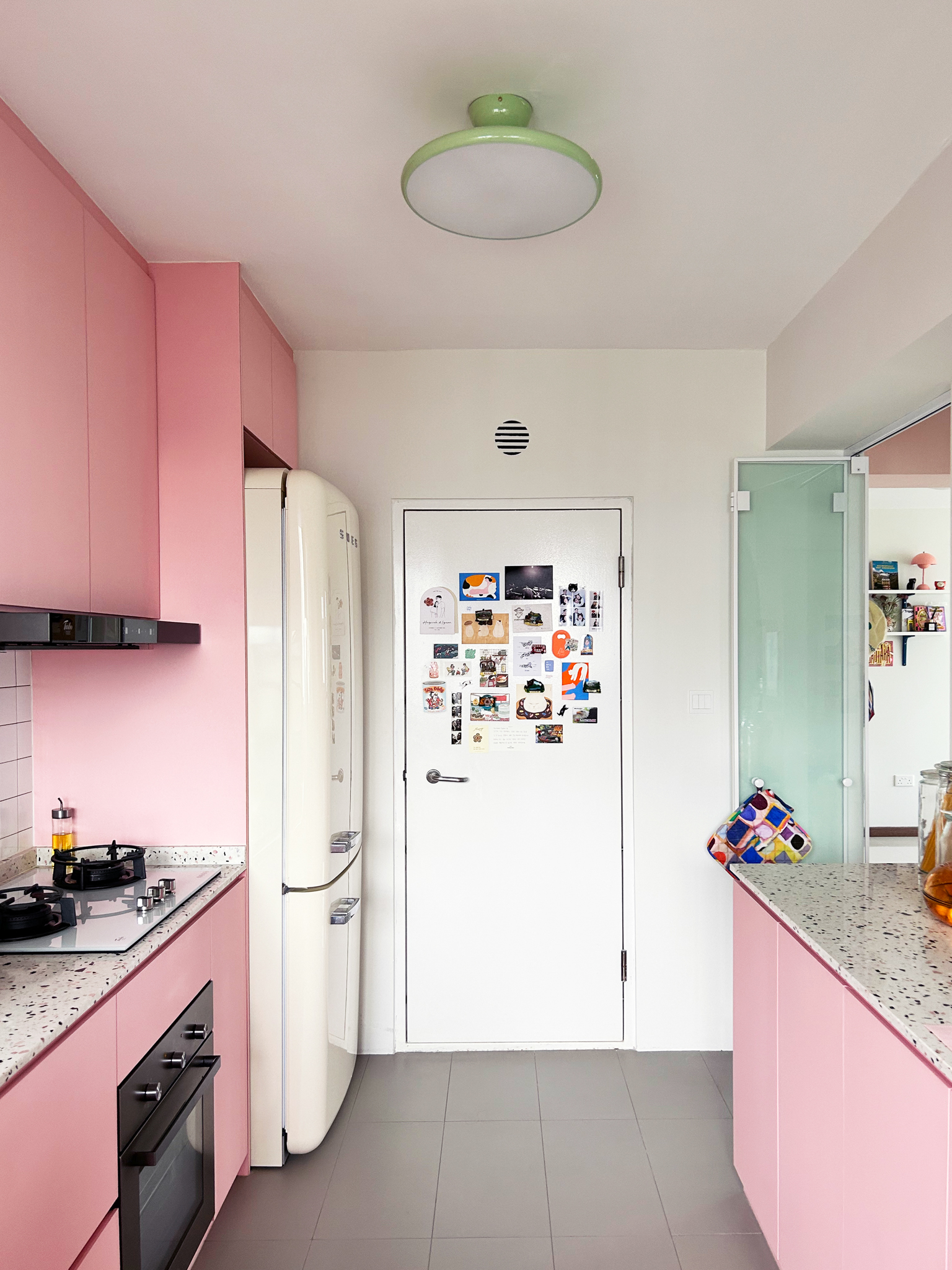 A quirky 93sqm home with pops of colour and 3 cattos - Pink kitchen cabinets, white refrigerator, black stove, speckled