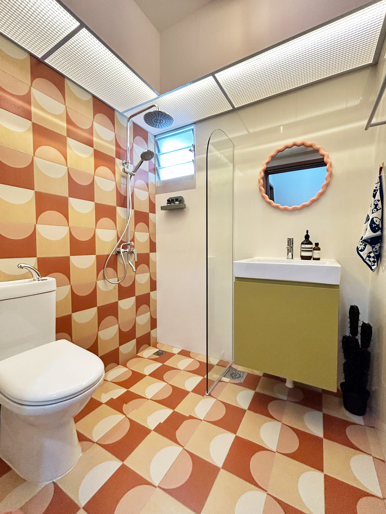 A quirky 93sqm home with pops of colour and 3 cattos - Patterned tiles, modern fixtures, glass shower enclosure, oval mirror