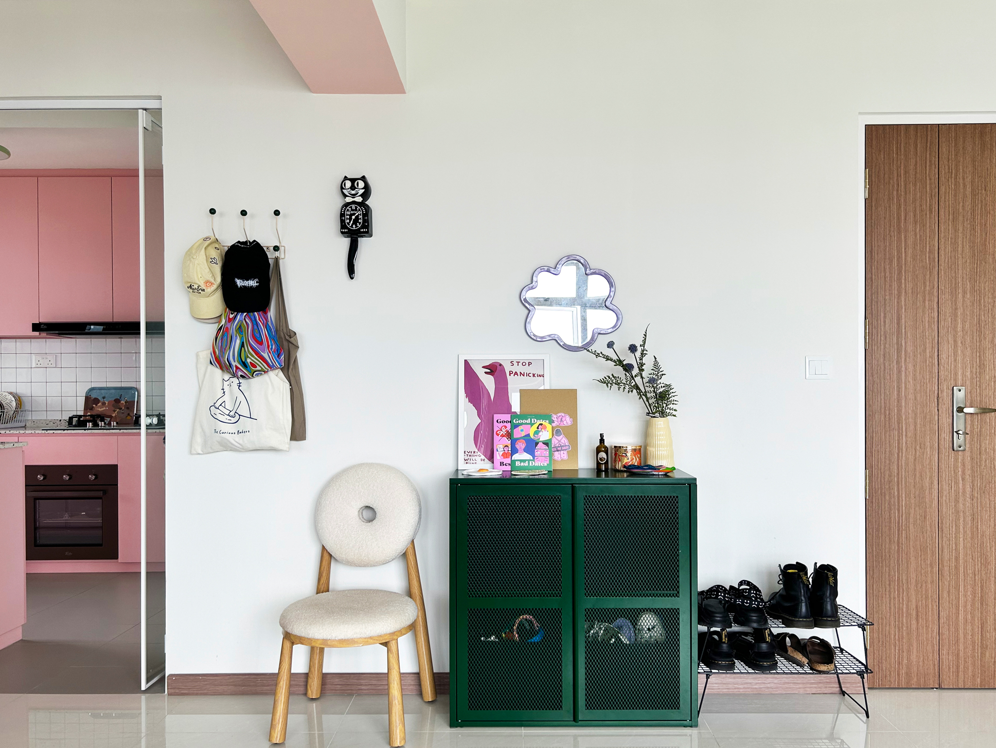 A quirky 93sqm home with pops of colour and 3 cattos - Pink kitchen cabinets, white tiled backsplash, black stove, colorful