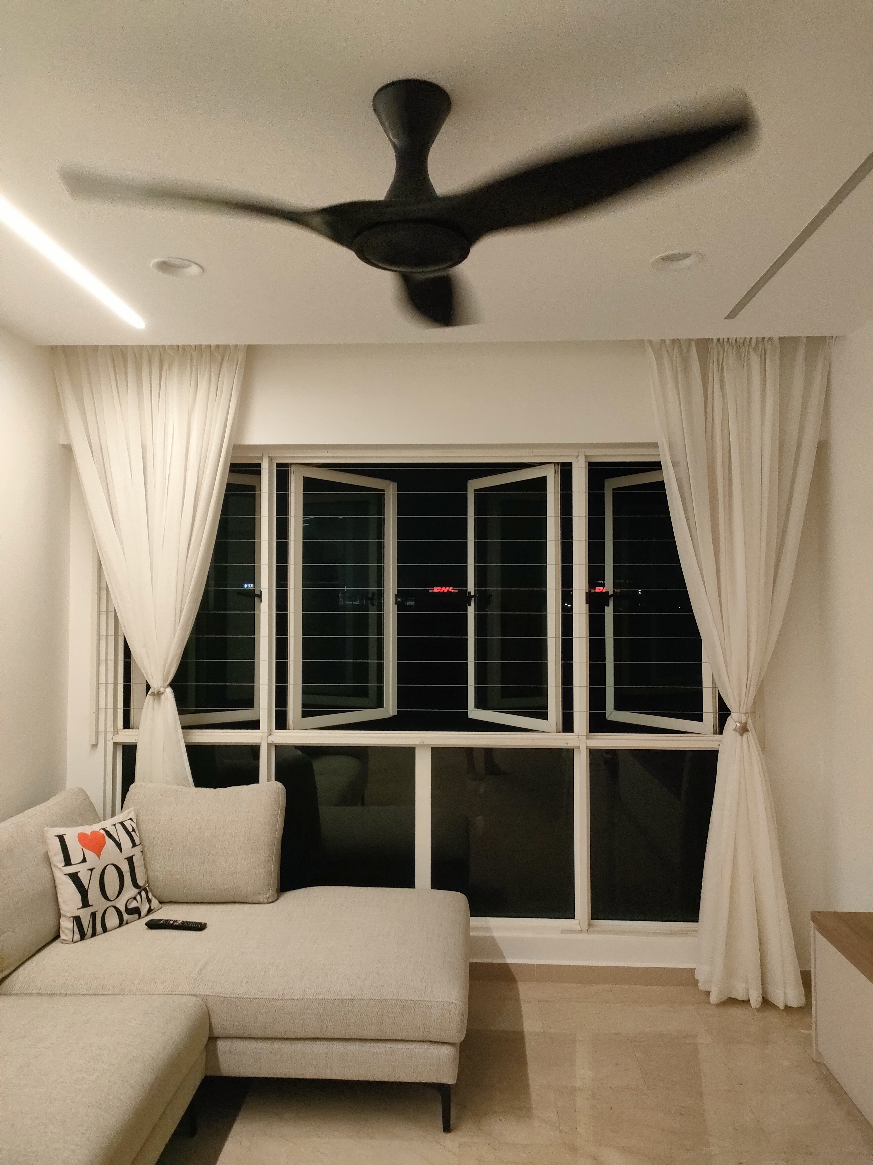 Living room where we gather for family bonding - Modern living room, cozy seating, beige sofa, white curtains, large window