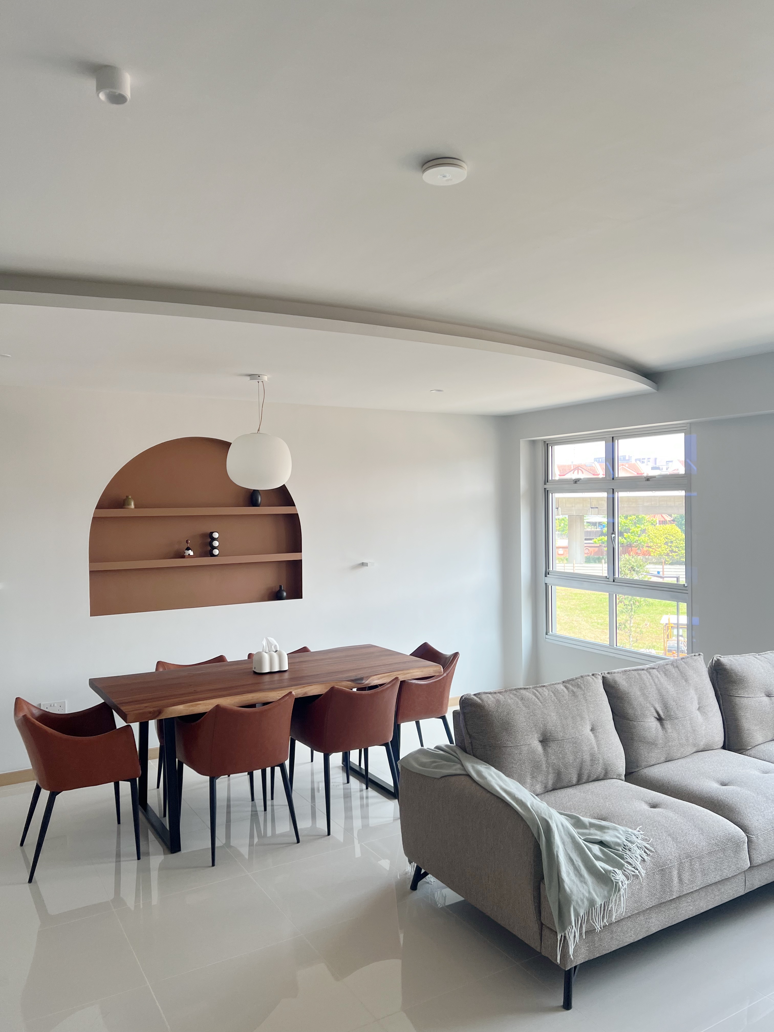 Step Inside: Our Cosy Living Room - Modern minimalist dining room with sleek wooden table and chairs, contemporary light