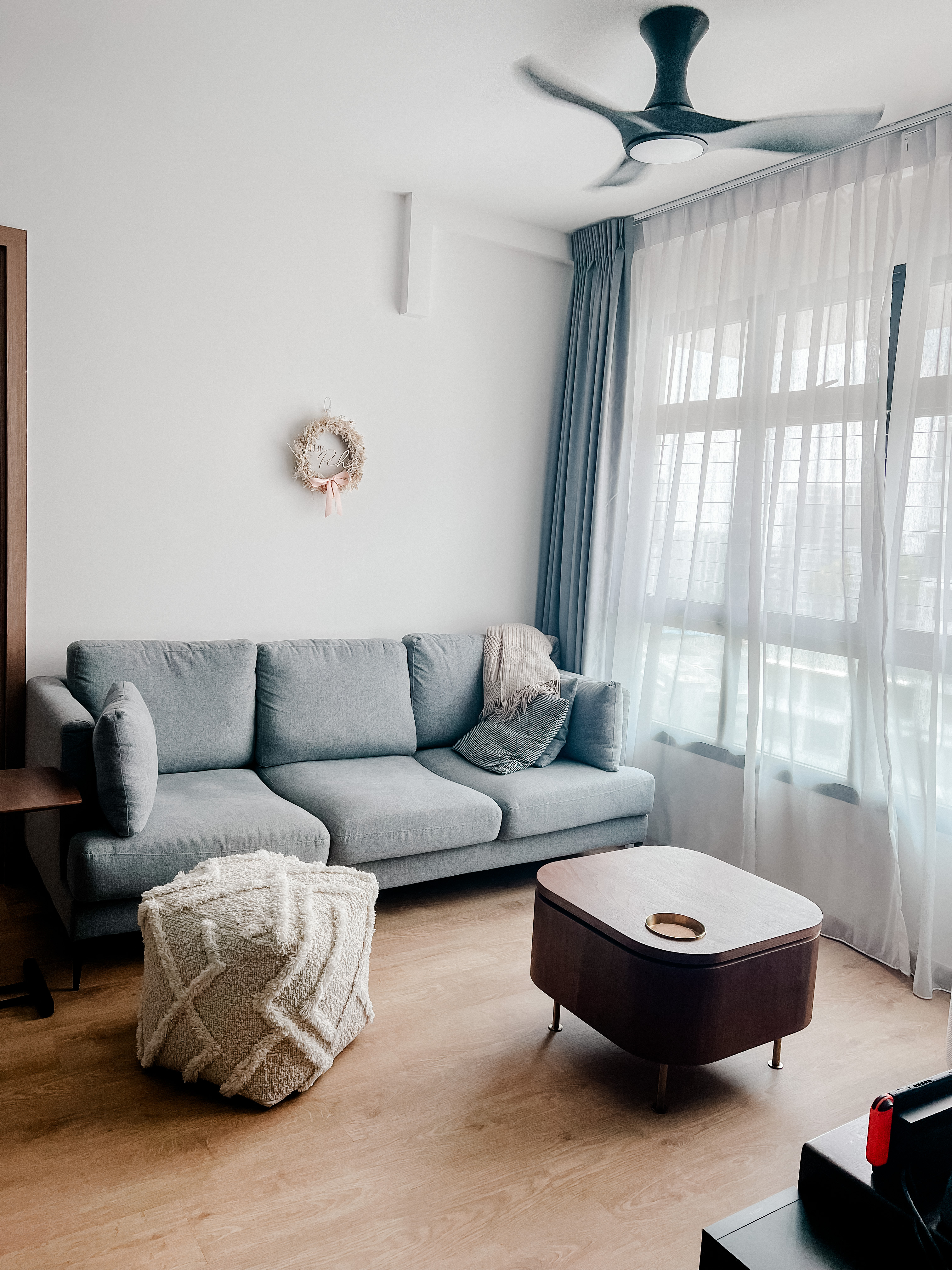 Living Room - Sanctuary of Style and Comfort - Light gray sofa, light wooden floor, modern ceiling fan, sheer curtains, cozy