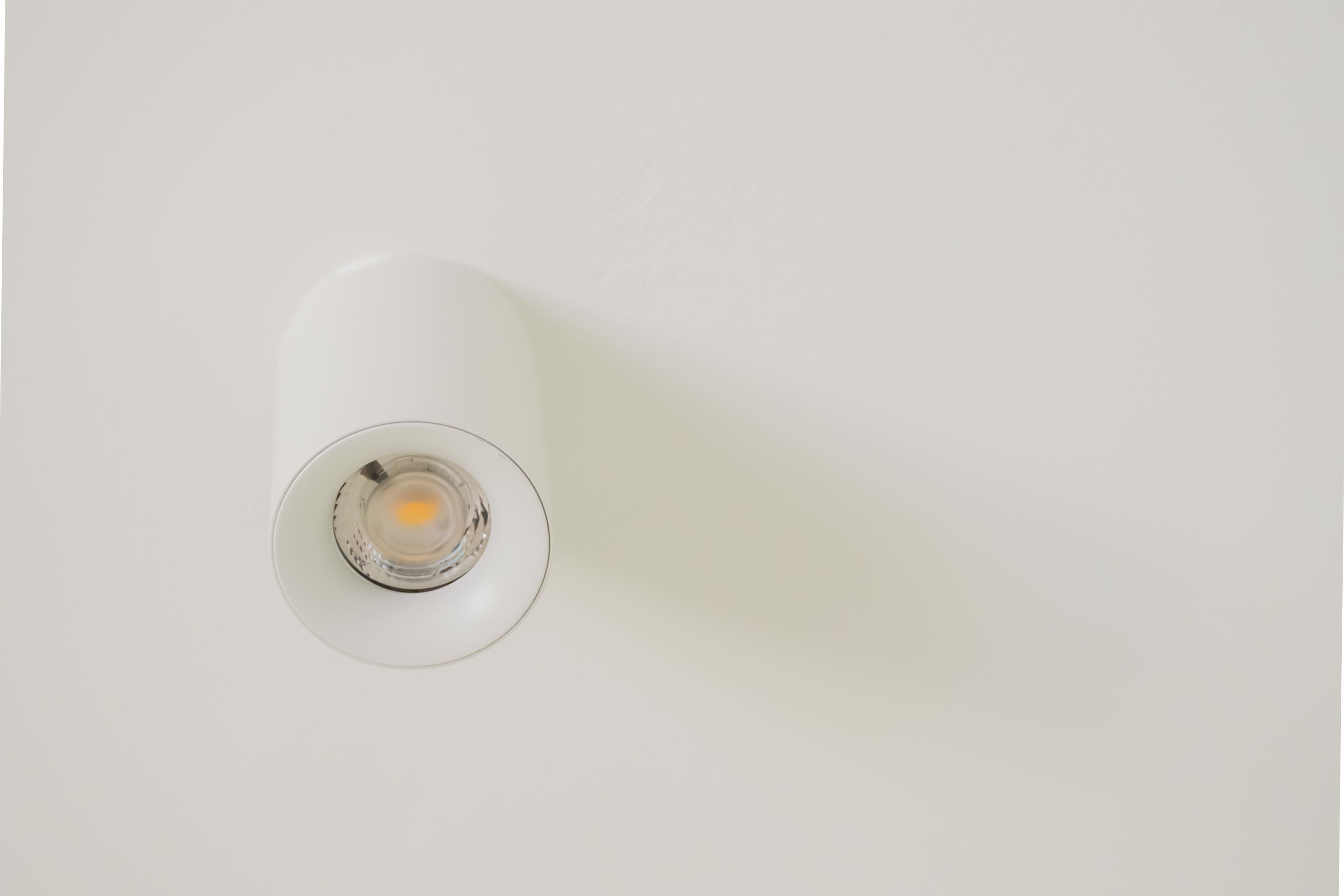 Minimal and clutter free living room - White ceiling light fixture, modern design, sleek surface, minimalist style, soft